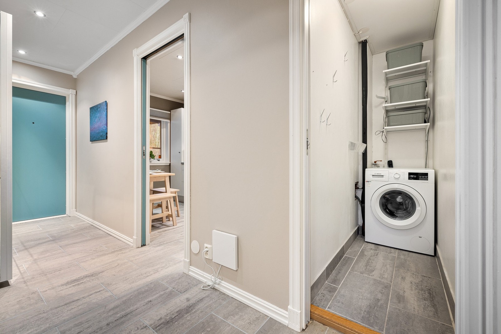 Boligen har i dag et praktisk vaskerom med hylleinnredning med egen adkomst fra gang Galleribilde