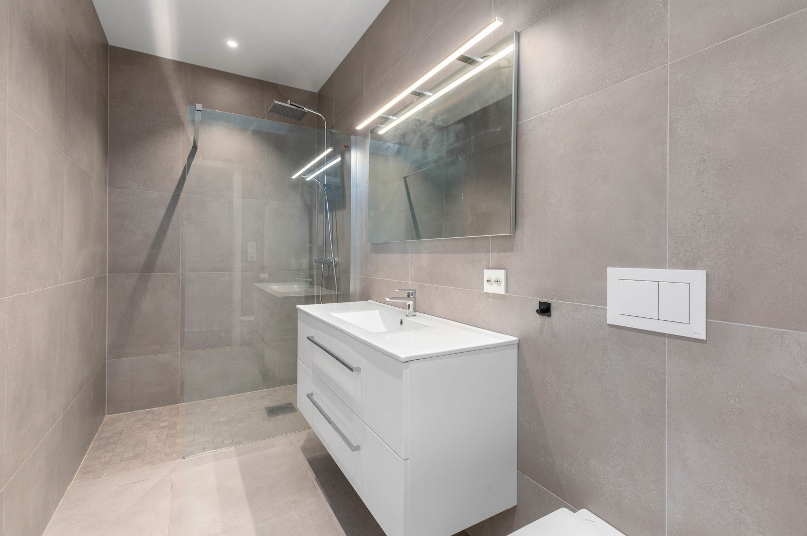 På badet i underetasjen er det vegghengt toalett, baderomsinnredning og dusjhjørne Galleribilde