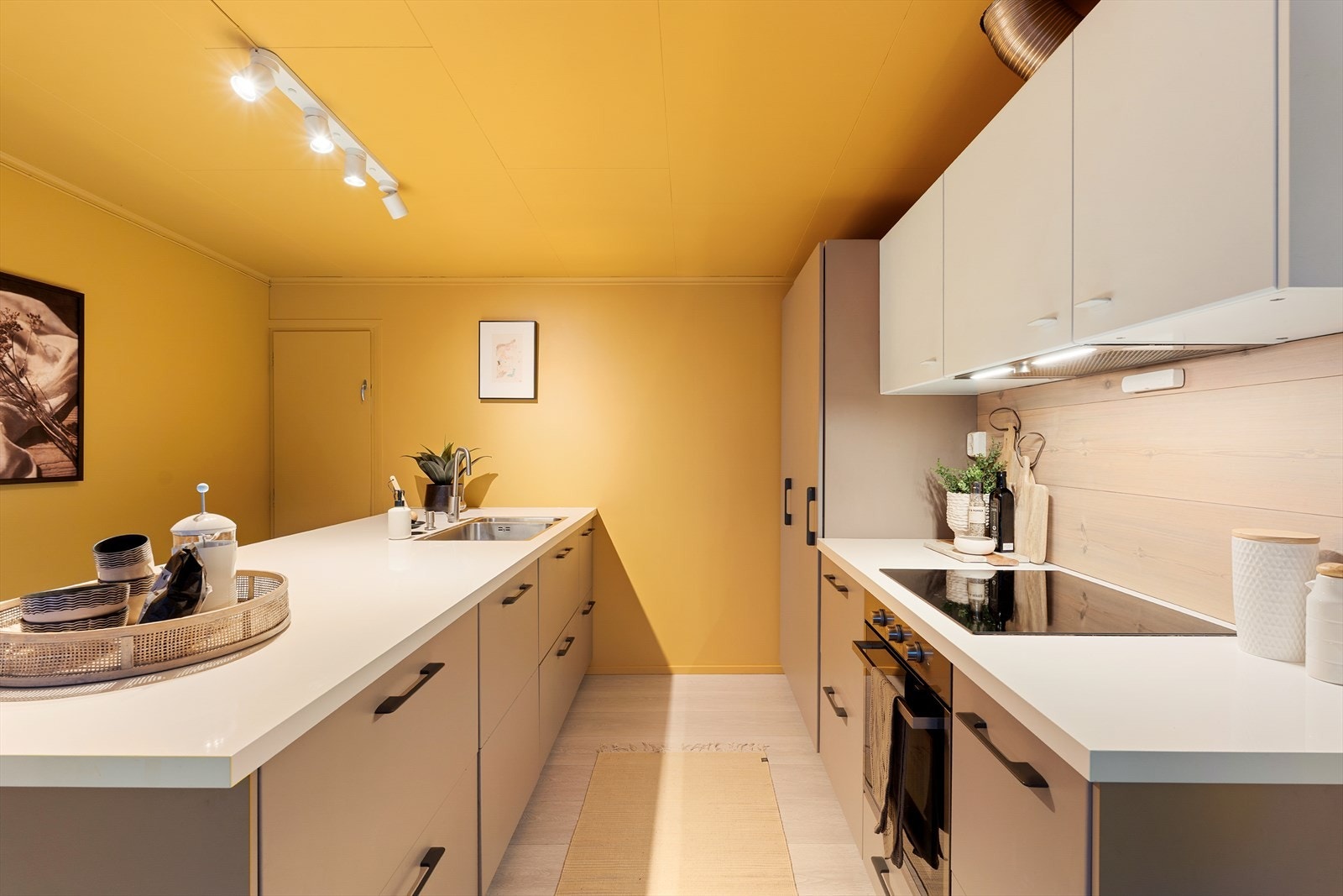 Kjøkkenet er moderne utformet med slette fronter i tidløse fargetoner. Videre har sonen for kokkelering integrert platetopp, stekeovn, kjøleskap og oppvaskmaskin. Galleribilde