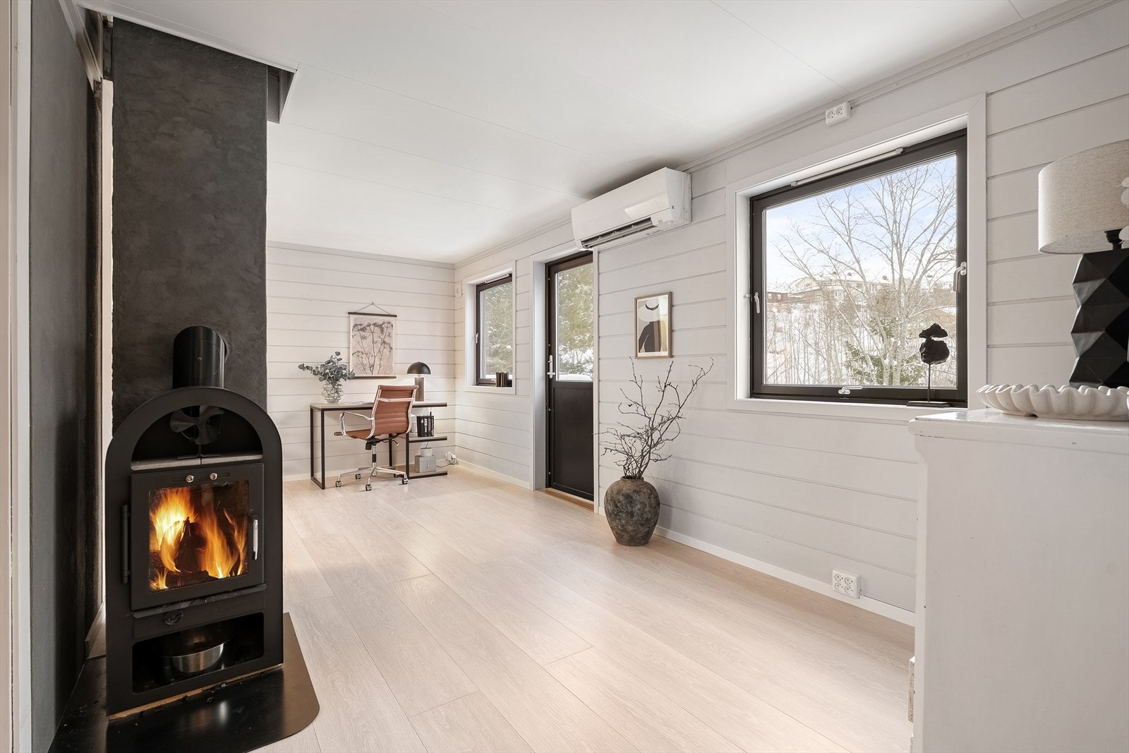 Peisinnsatsen i 1. etasje gir en lun og behagelig varme året rundt, supplert av en varmepumpe for ekstra komfort. Rommet har også plass til flere møbleringssoner, slik at man enkelt kan skape både sofakrok, lesesone eller lekeområde etter behov. Galleribilde