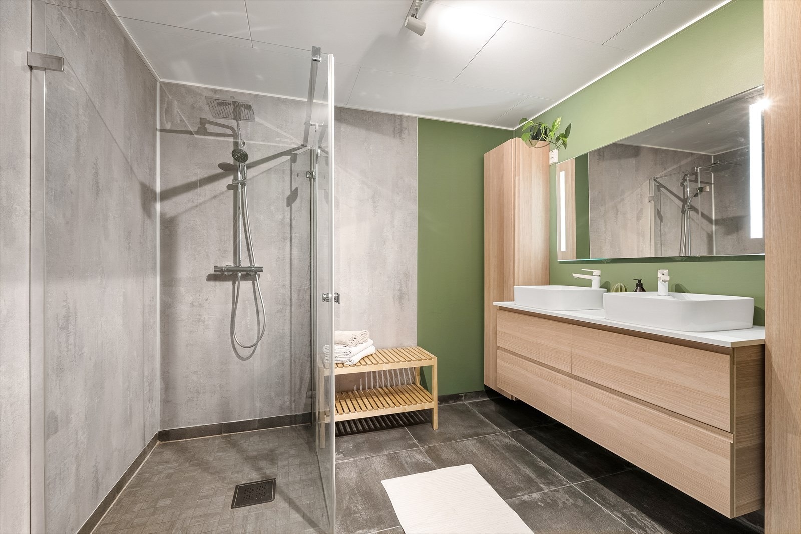 Her har man en moderne innredning fra IKEA med dobbeltservant levert av Megaflis. Baderommet har gunstige lagringsmuligheter til håndklær og baderomsartikler i skuffer og høyskap på hver side. Varmekabler i gulv sørger for en lun komfort året rundt. Galleribilde