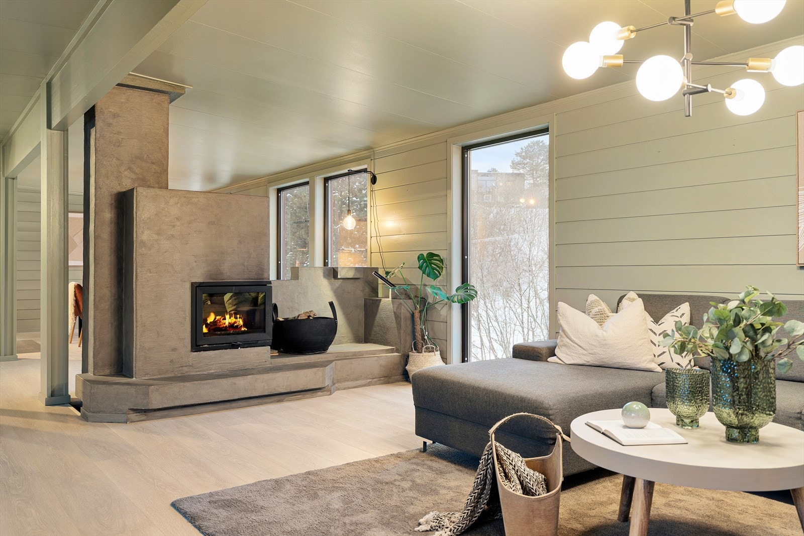 Stuens behagelige størrelse gir rom for sofagruppe, TV-hjørne og øvrig interiør. En koselig peisinnsats skaper en lun atmosfære året rundt, og etasjen gir også rom for flere sittegrupper og soner, som egner seg godt både til avslapping og sosialt samvær. Galleribilde