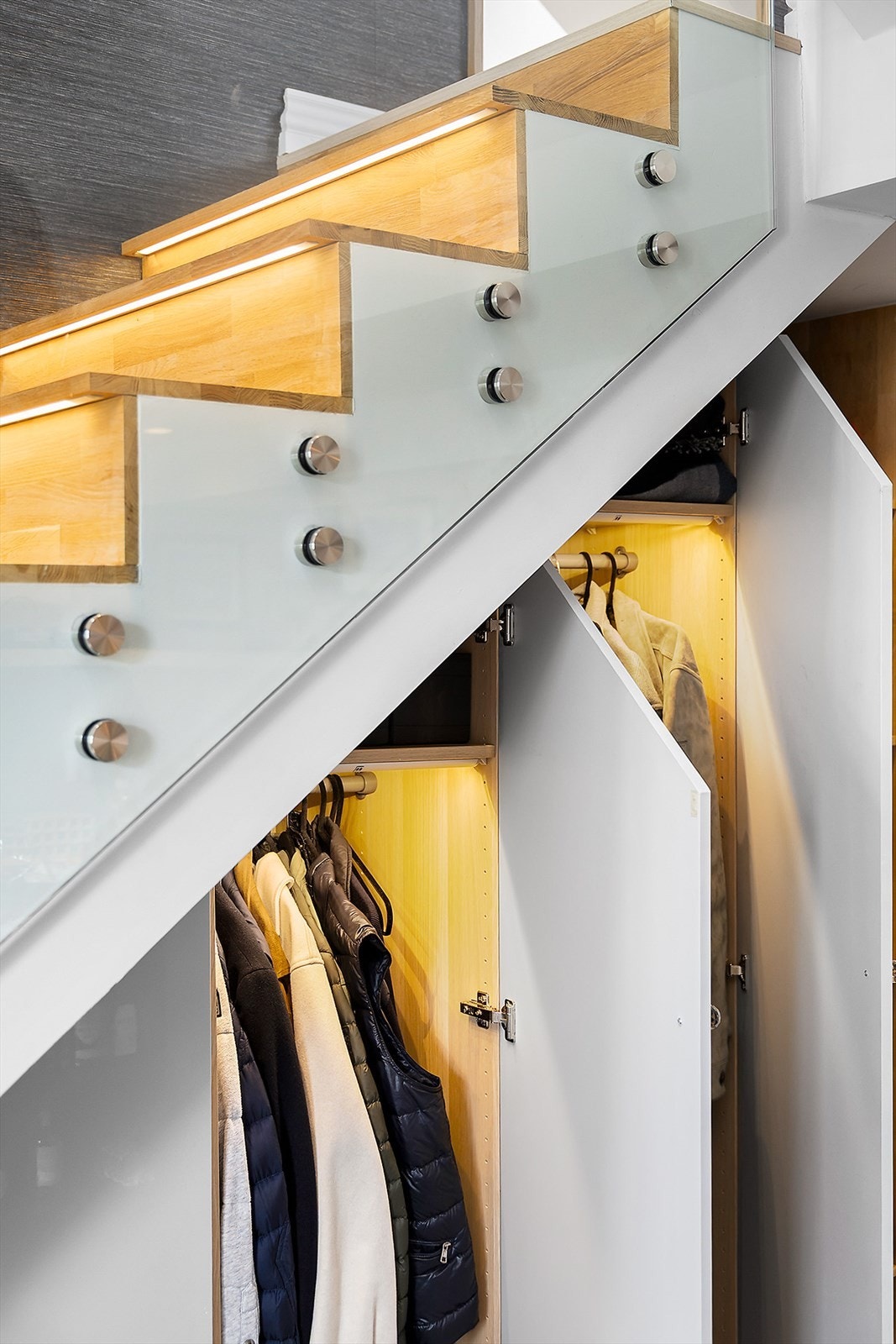 Under trappen finner du en oppbevaringsløsning med plassbygde skap og belysning. Galleribilde