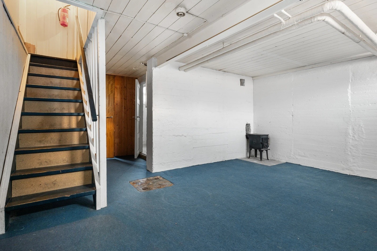 Trapp ned til kjellerstua med peis. Vaskerom til høyre. Galleribilde