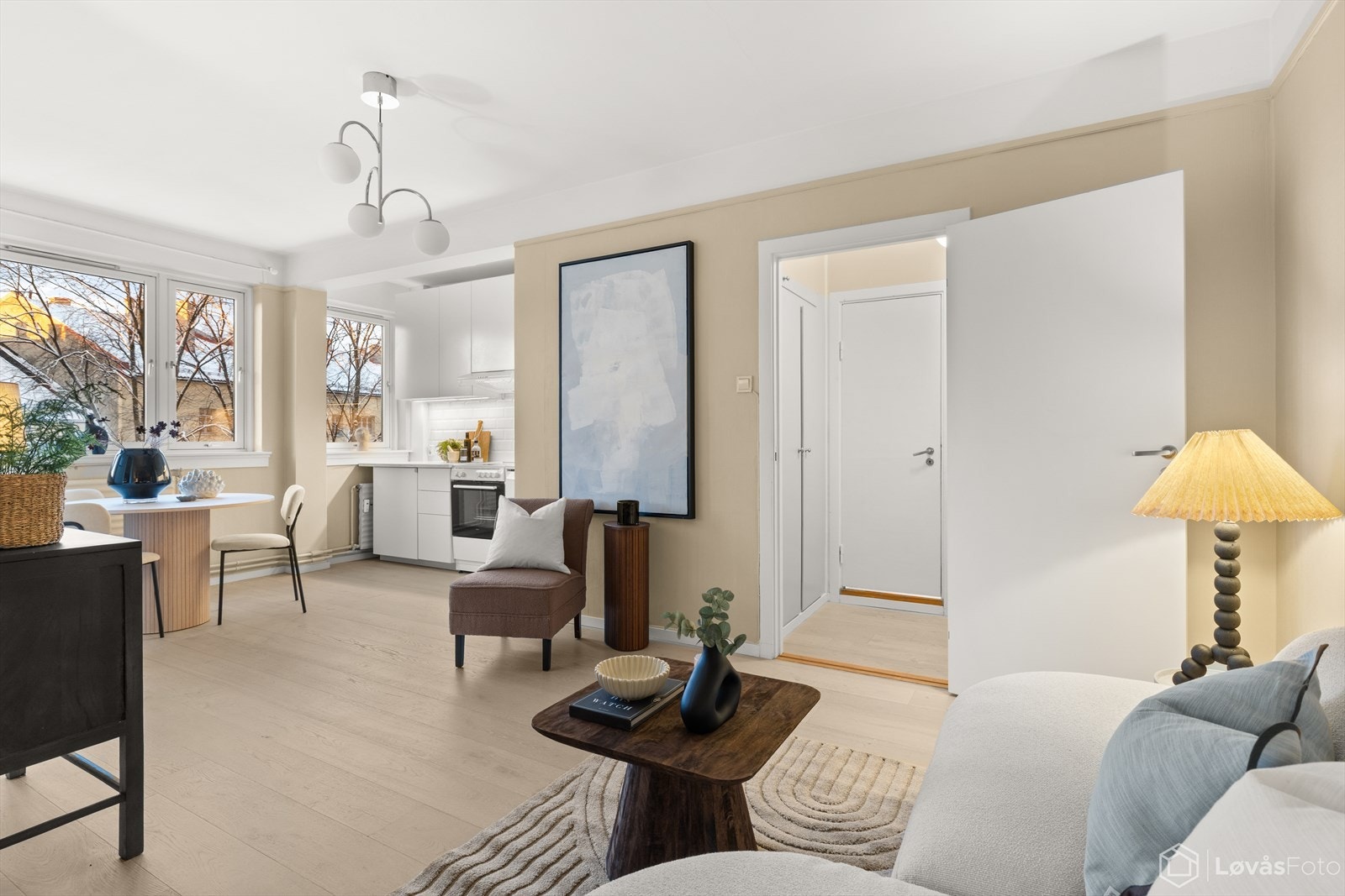 Den åpne stue og kjøkkenløsningen blir fylt med rikelig naturlig lys via store vinduer Galleribilde