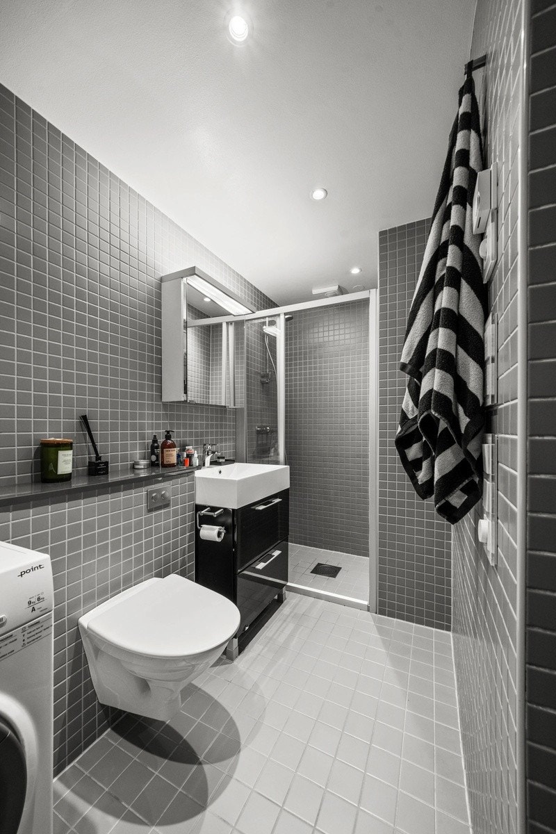 Flislagt bad av behagelig størrelse med gulvvarme og downlights. Galleribilde