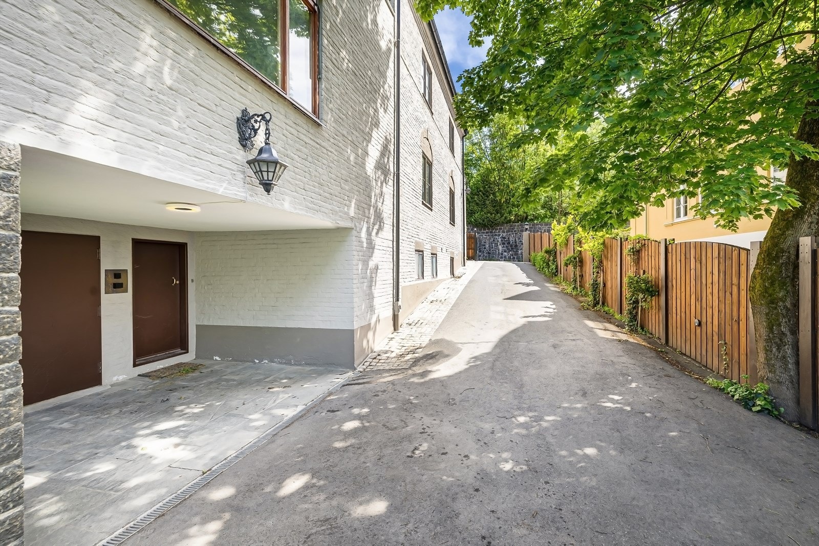 Asfaltert nedkjørsel til garasje og inngang til kjeller Galleribilde