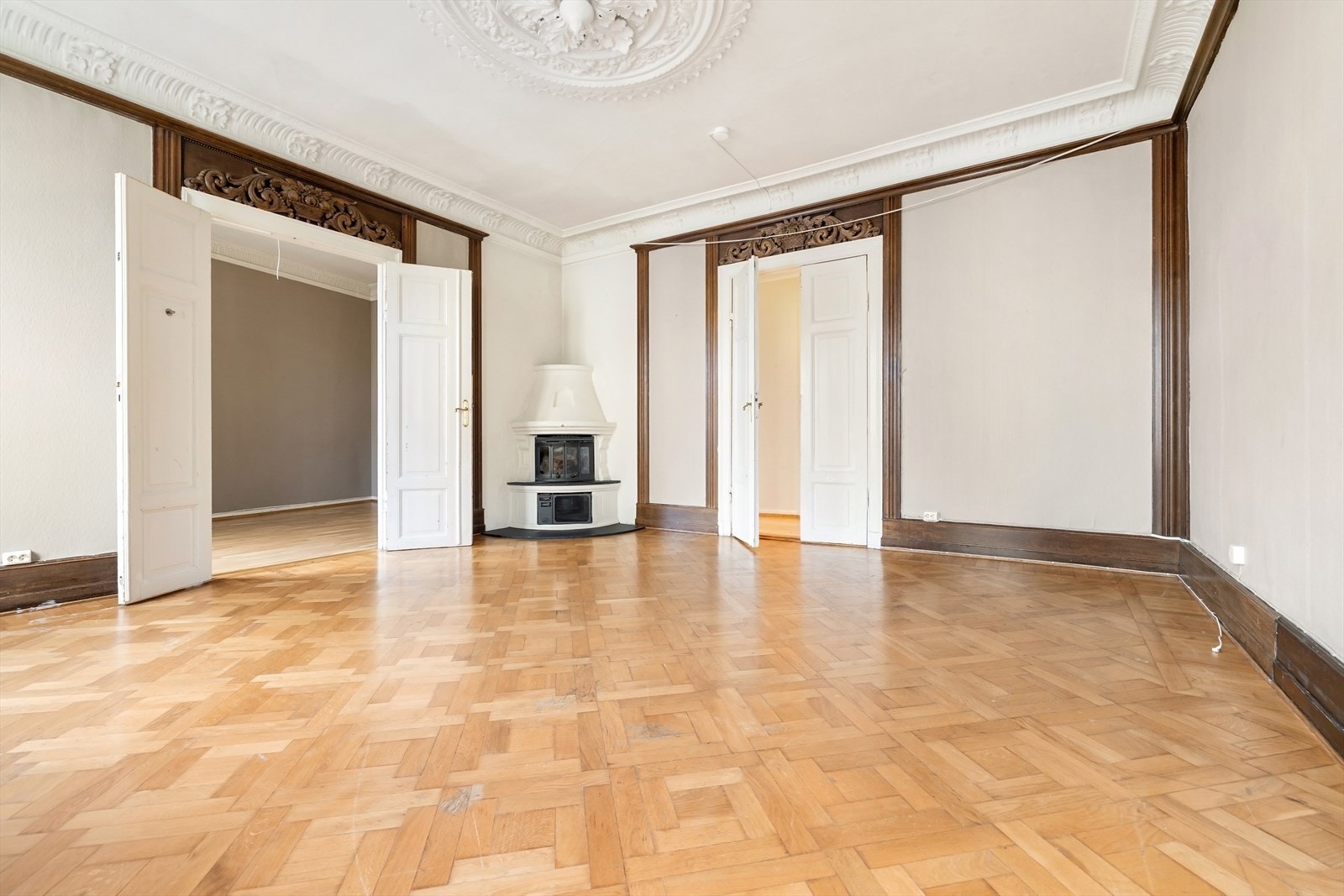 Vakre detaljer som stukkatur, rosetter, originalt gulv, doble fløydører, god takhøyde og peis skaper en helt spesiell atmosfære Galleribilde