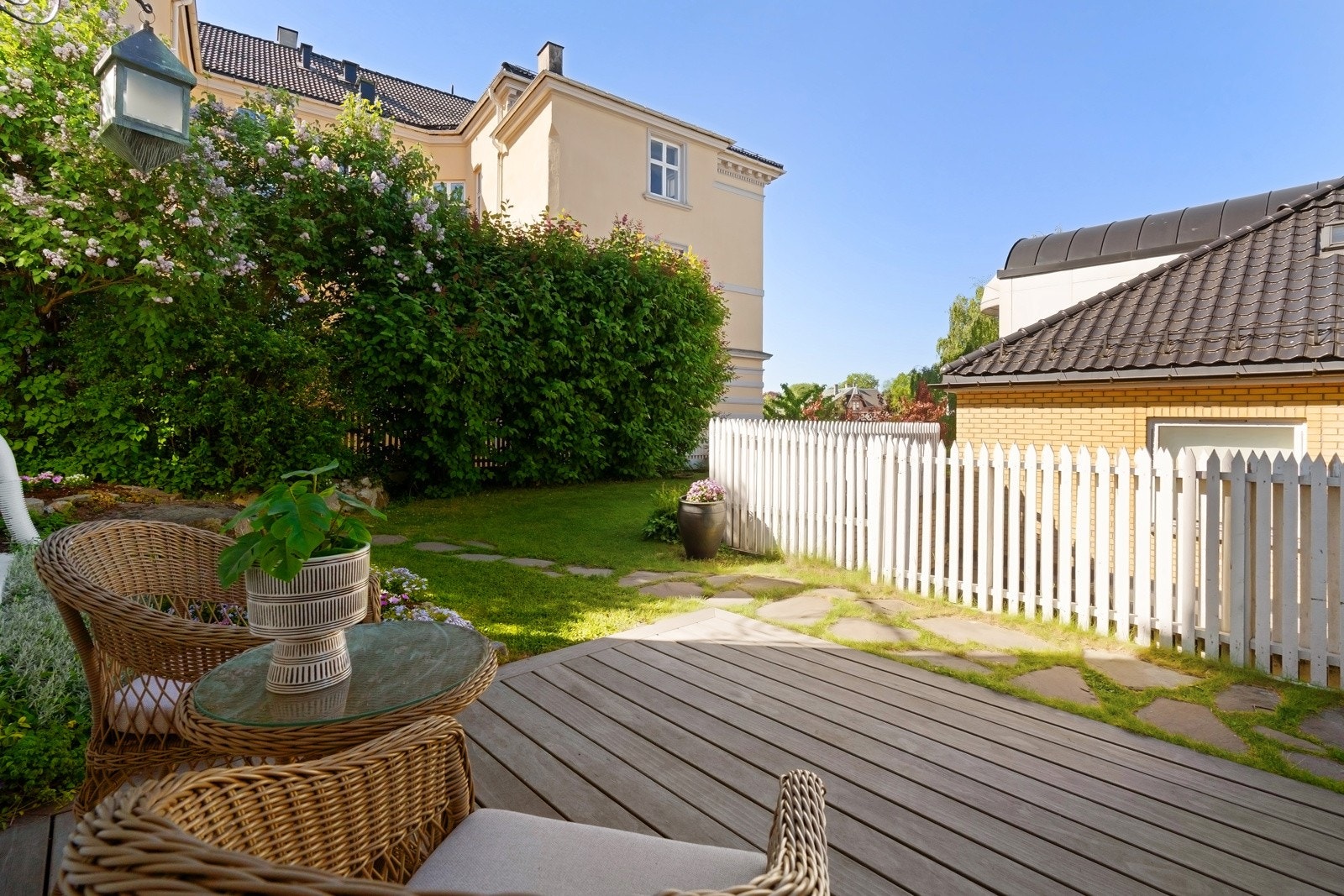 Felles markterrasse ved siden av et skiferdekket inngangsparti.