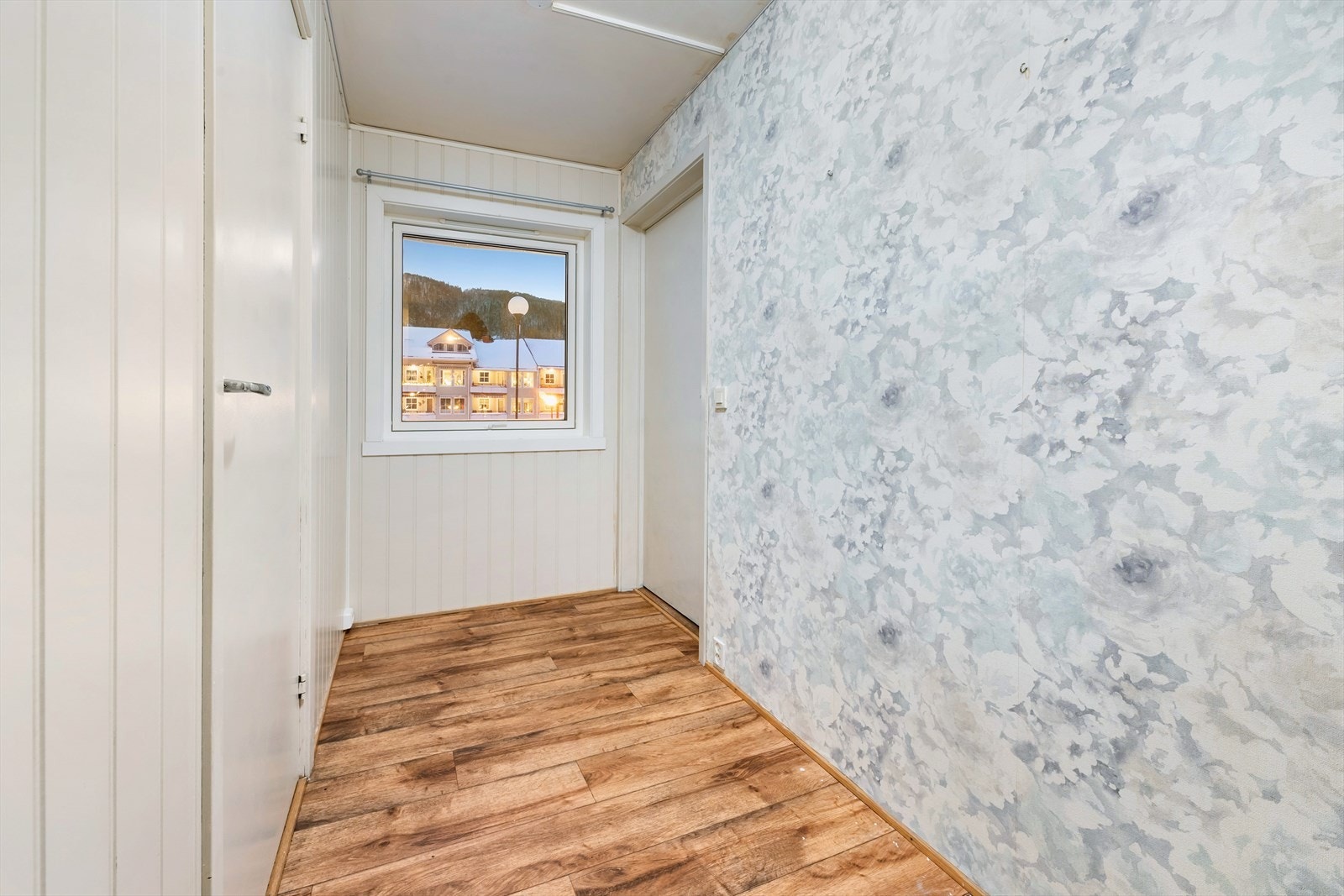 Vinduet i gangen gir utsikt mot det fine hageområdet i borettslaget. Galleribilde