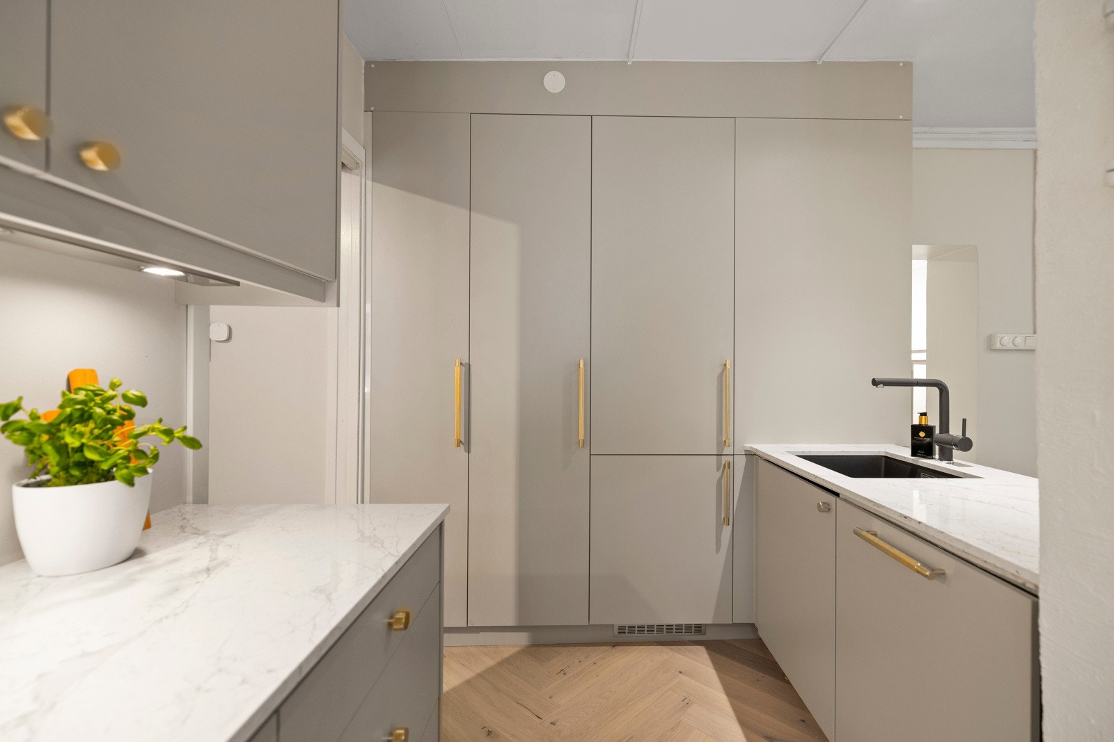 Kjøkkenet har en stilfull kompositt benkeplate og underlimt kum fra 2024, samt integrerte hvitevarer som sikrer en helhetlig og moderne stil. Galleribilde