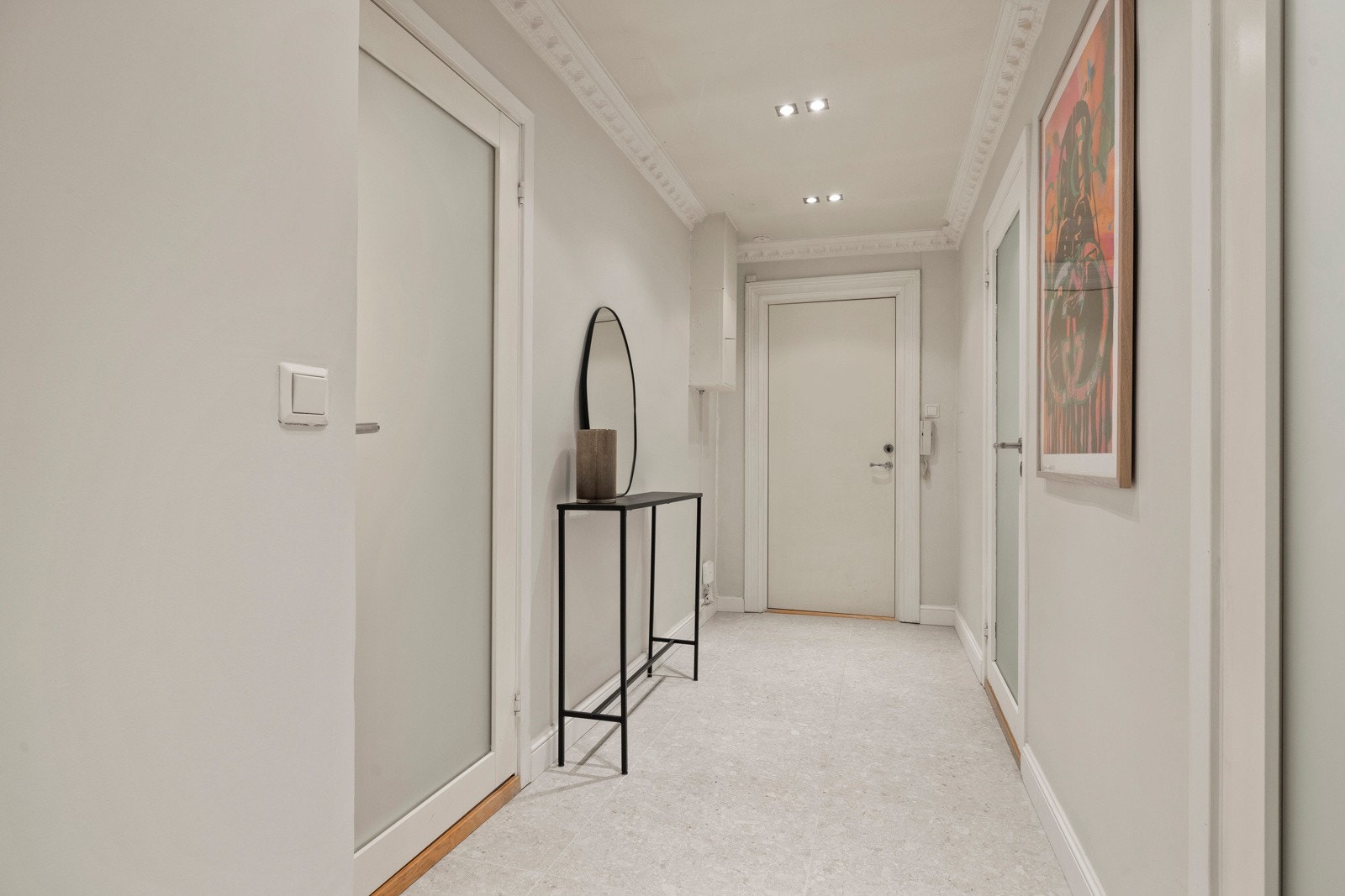 Velkommen inn! En lys og innbydende entré som gir et flott førsteinntrykk. Gulvet er flislagt og ny lekker stukkatur setter en eksklusiv ramme for rommet. Galleribilde