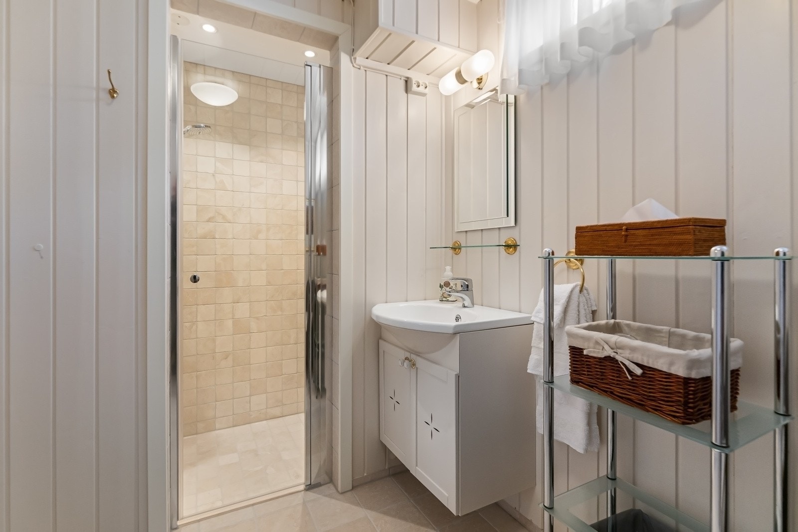 Badet i kjelleren ble pent oppgradert i 2024 og har lysbeige marmorfliser på gulvet, gulvvarme og paneloverflater malt i en harmonerende nyanse. Galleribilde