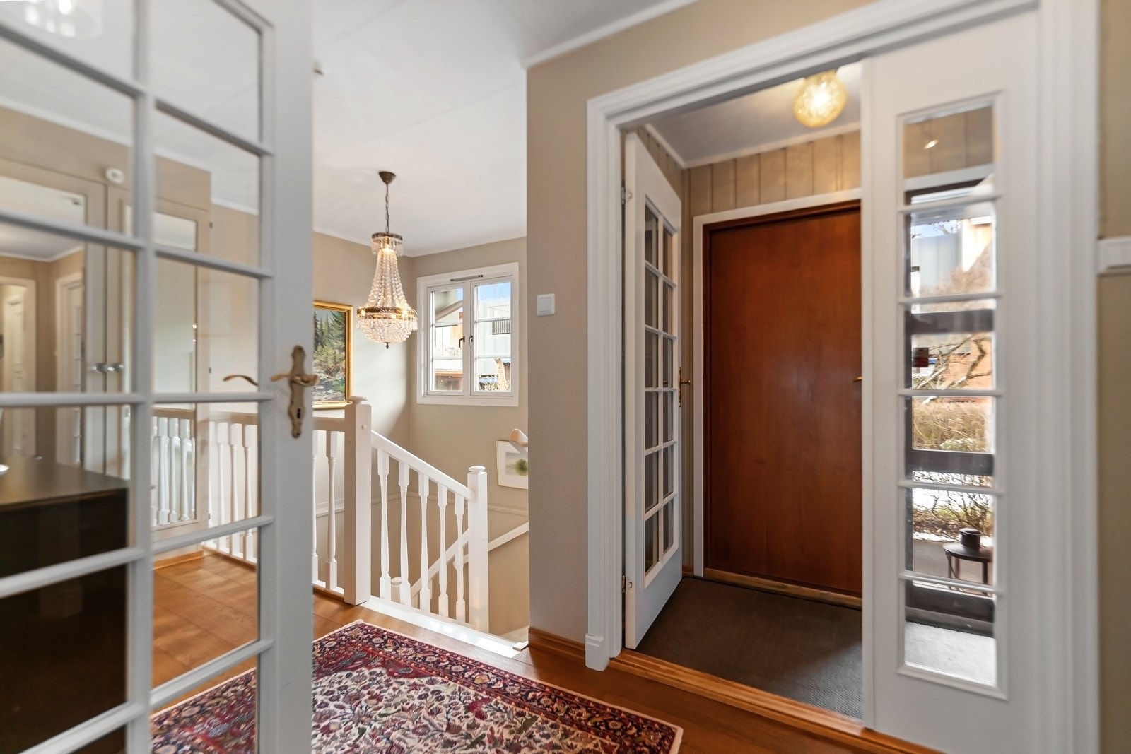 Boligen har adkomst fra inngangspartiet med malte panelvegger, flislagt gulv og ytterdør med sidevindu. Galleribilde