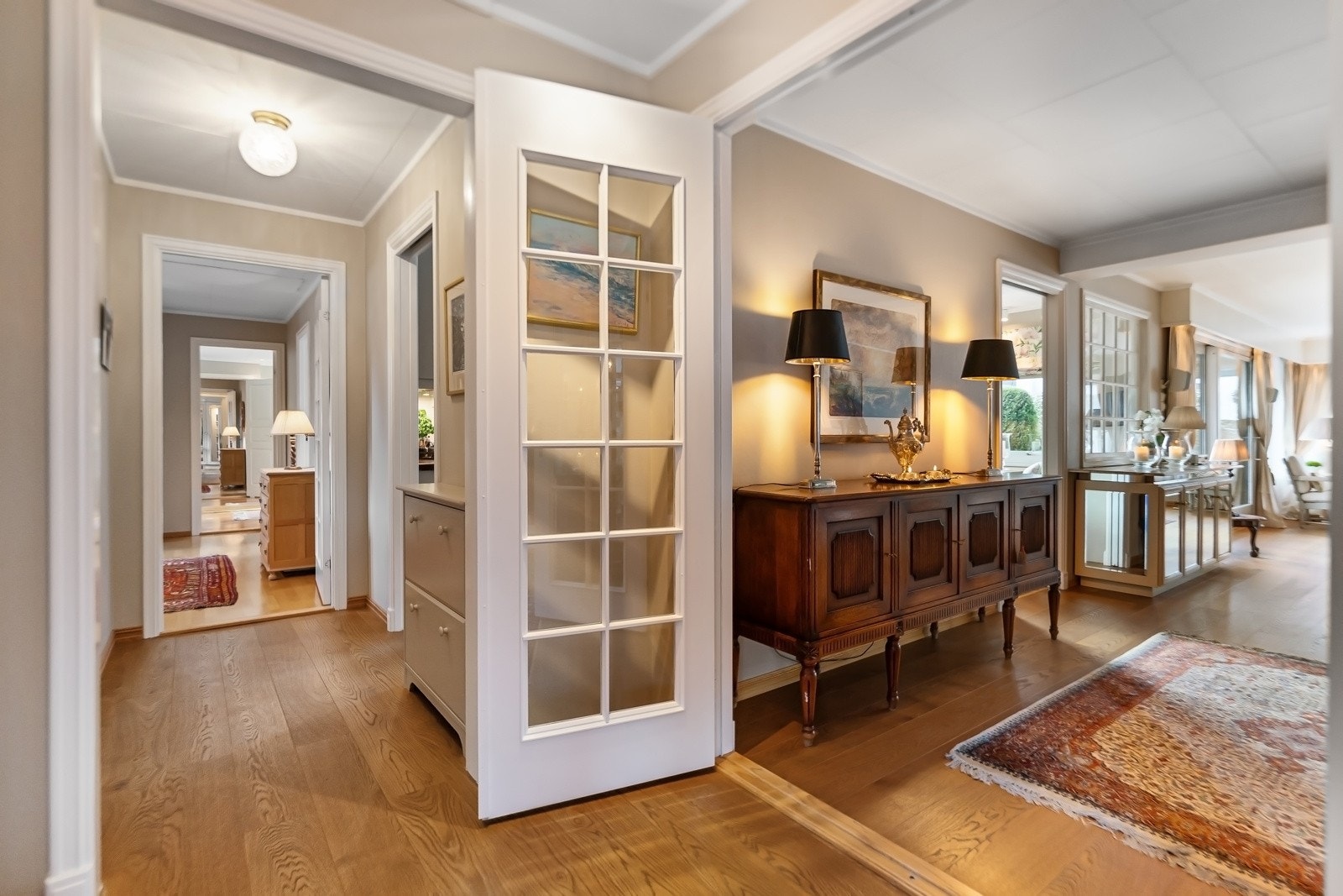 Fra hallen leder en dør inn til en sidefløy med 2 soverom, TV-stue/kontor, bad og toalett, samt mellomgang til kjøkken og vaskerom. Galleribilde