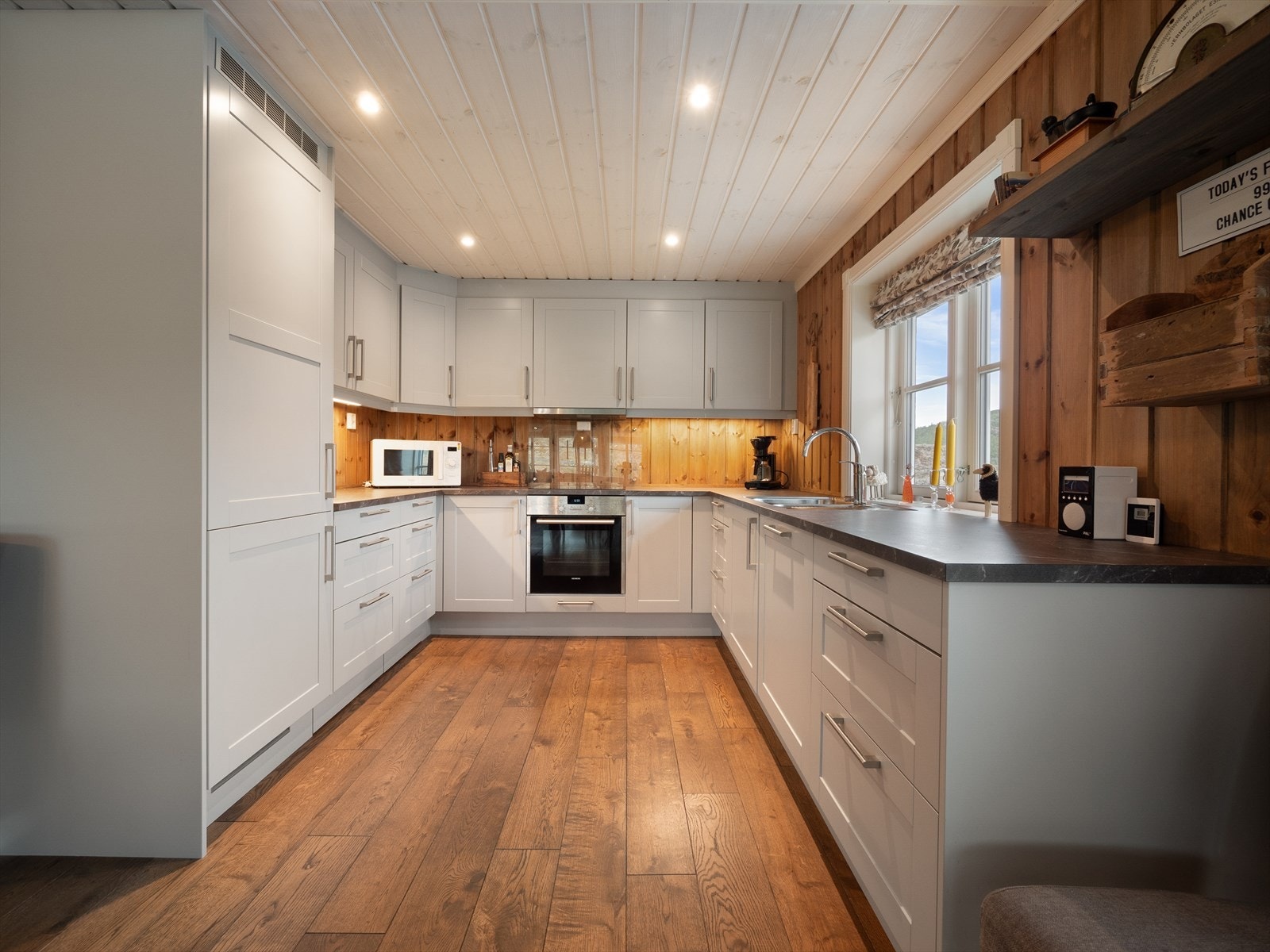 Lekkert kjøkken med rikelig skap- og benkeplass. Kjøkkenet har stilrene, profilerte fronter og godt med naturlig lys fra vinduet over benken. Galleribilde