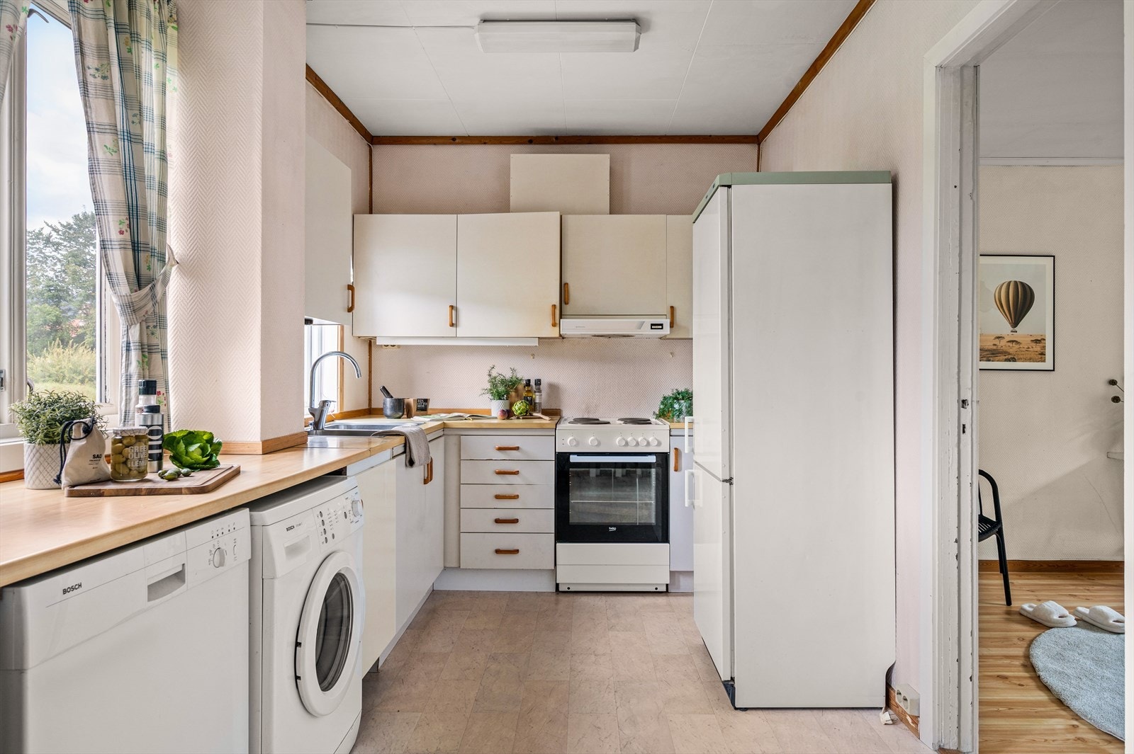 Innholdsrikt kjøkken med mye skap- og benkeplass Galleribilde