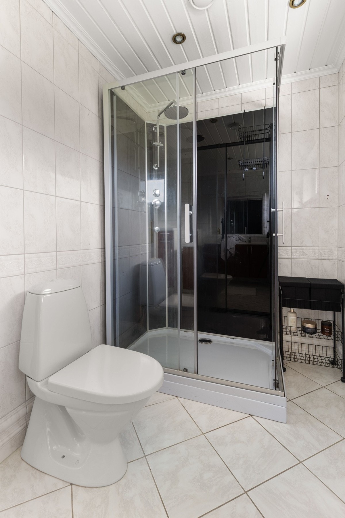 Badet er utstyrt med wc, dobbelservant med innredning, stort speil og dusjhjørne med herdet glass. Galleribilde