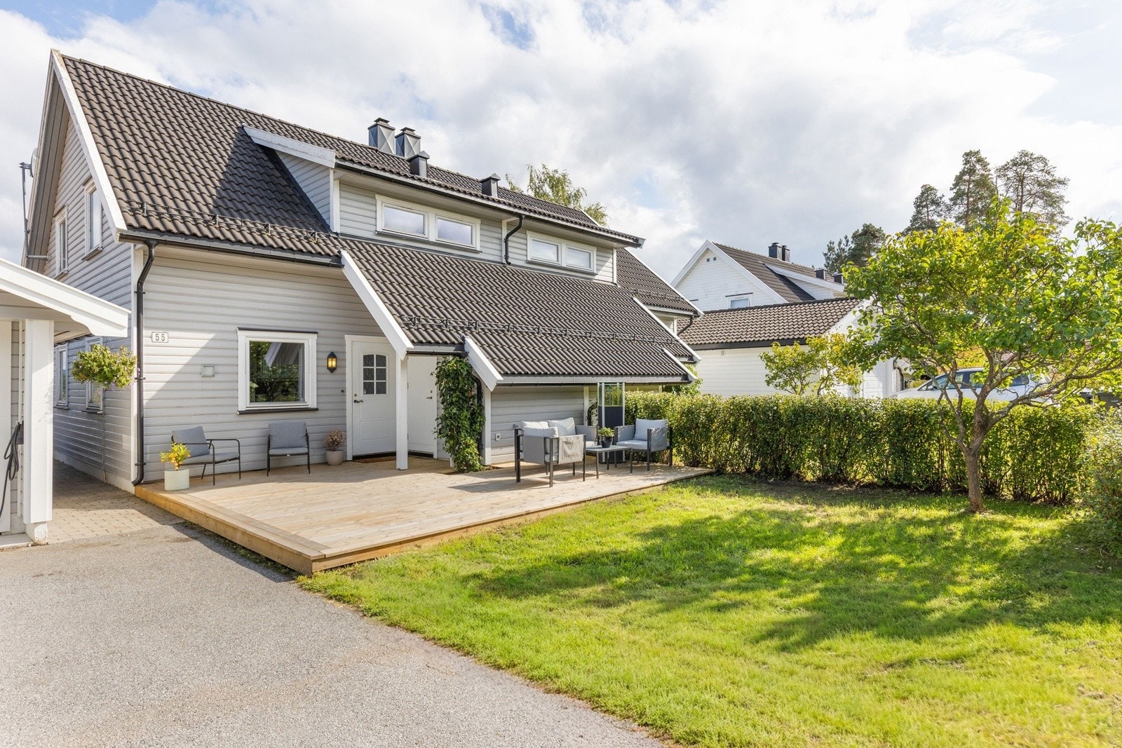 Pent opparbeidet eiendom med gressplen og skjermende beplantning . Galleribilde