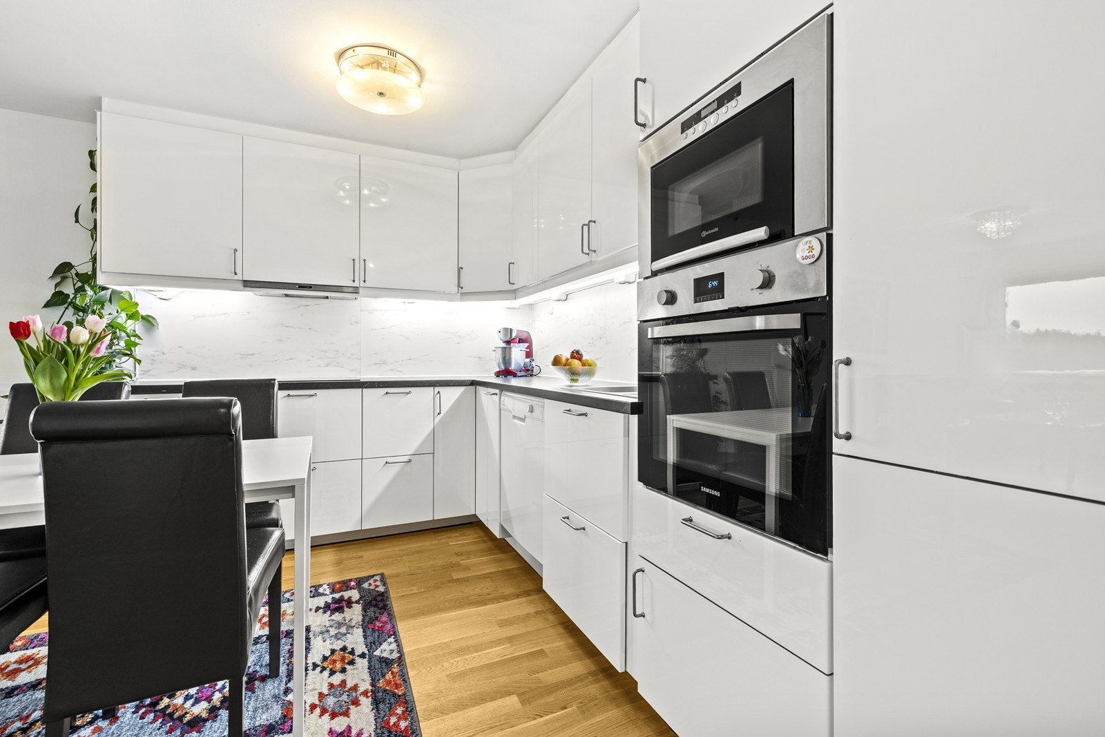 Kjøkkenet har slette, lyse fronter og integrert komfyr, kjøleskap og frys. Galleribilde