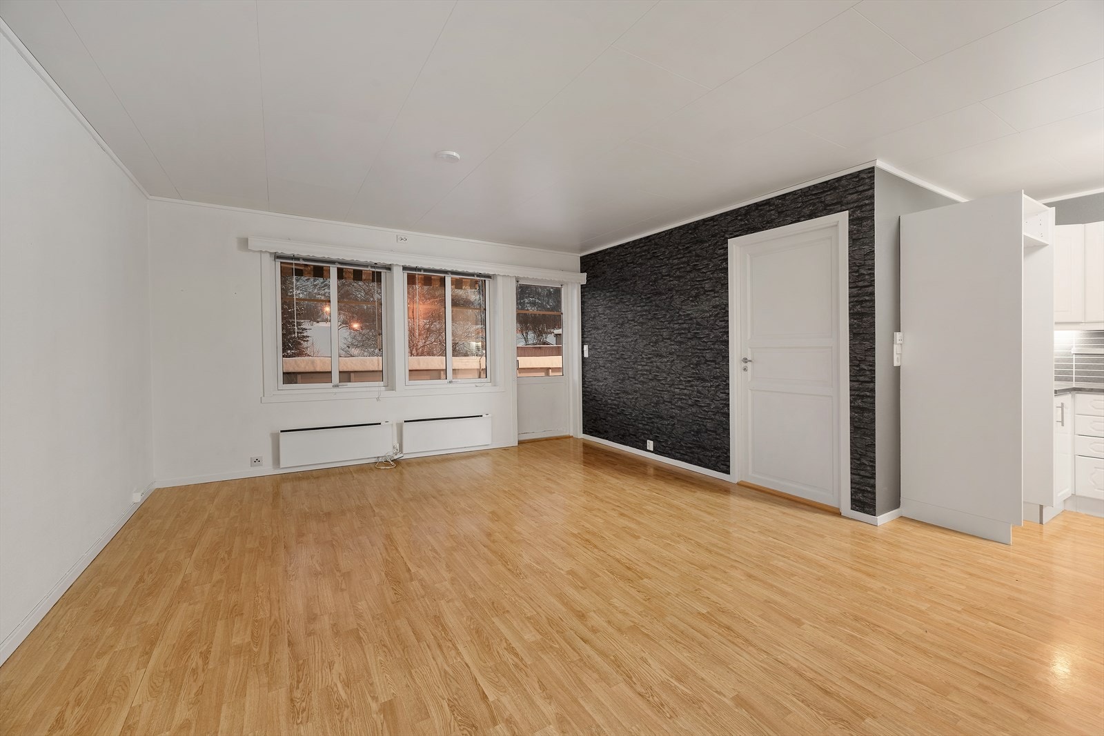 Stue med delvis åpen løsning mot kjøkken. Dør ut til vestvendt veranda. Galleribilde