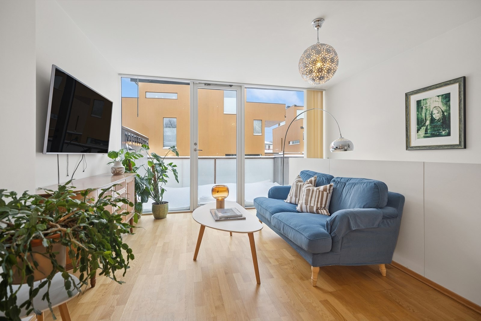 De store vindusflatene i stuen gir direkte tilgang til den vestvendte balkongen og slipper inn rikelig med lys. Her får du en sømløs overgang mellom inne og ute, perfekt for avslapning og sosialt samvær. Galleribilde