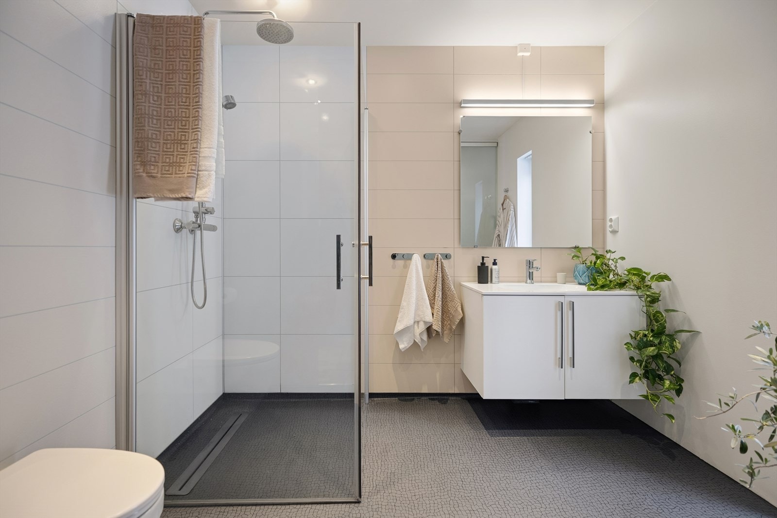 Badet er utstyrt med baderomsinnredning med servant, speil med egen belysning, veggmontert toalett,
dusjnisje med innfellbare glassdører samt en lufteventil for balansert ventilasjon. Galleribilde