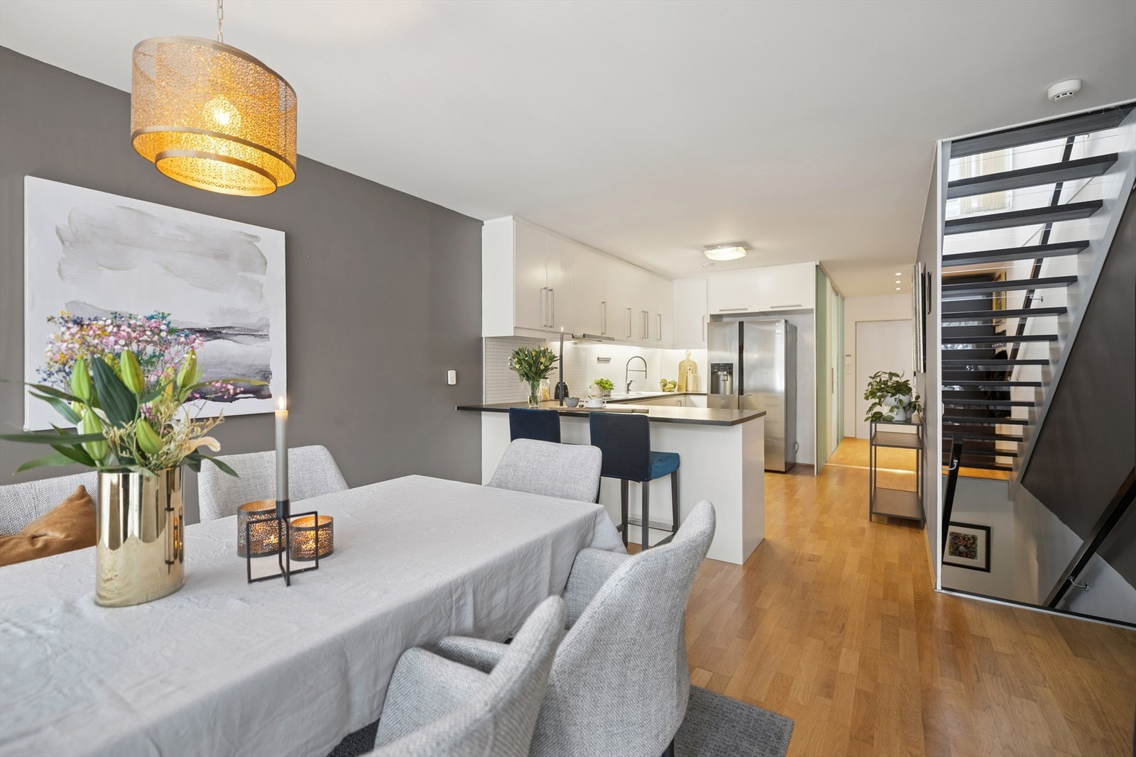 Den åpne kjøkkenløsningen mot spisestuen skaper en luftig og innbydende atmosfære, hvor naturlig lys
strømmer inn gjennom store vindusflater og gir en harmonisk forbindelse til de grønne omgivelsene utenfor. Galleribilde