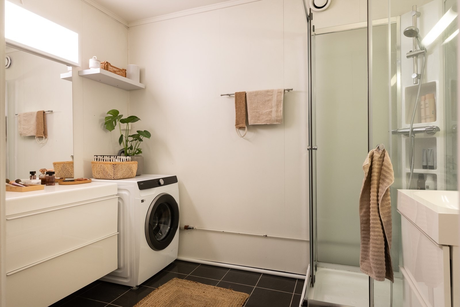 Romslig bad med opplegg for vaskemaskin, toalett og dusjkabinett Galleribilde