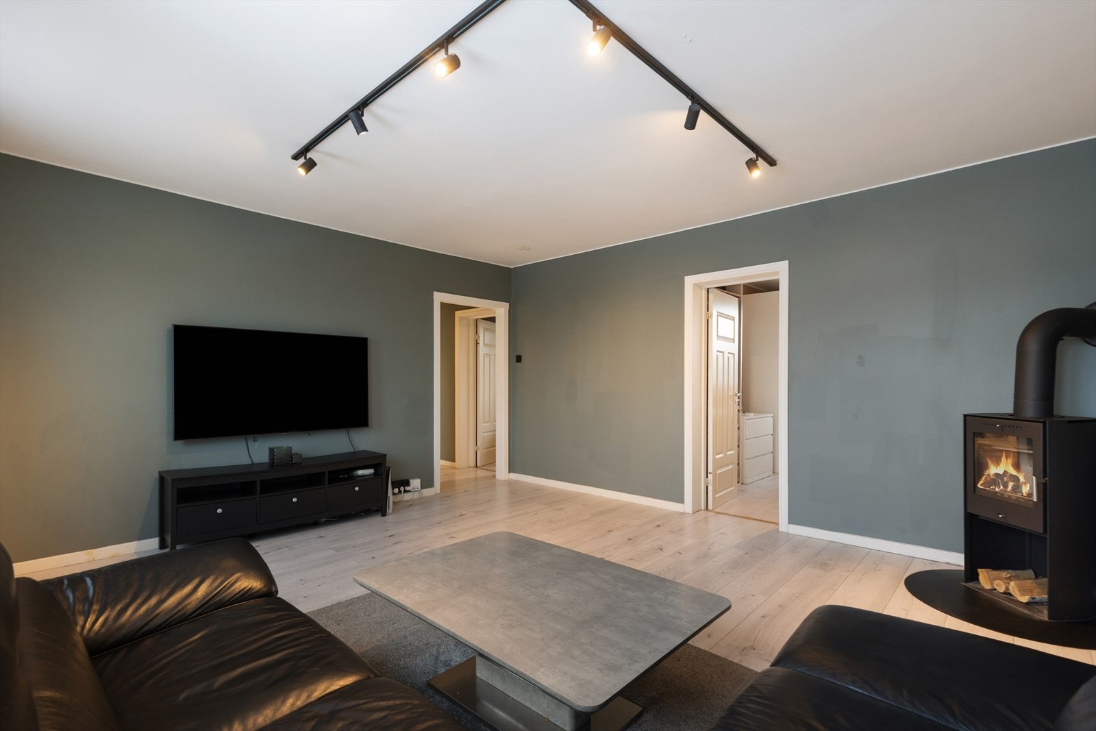 Lys og romslig stue med peis som naturlig blikkfang. Galleribilde