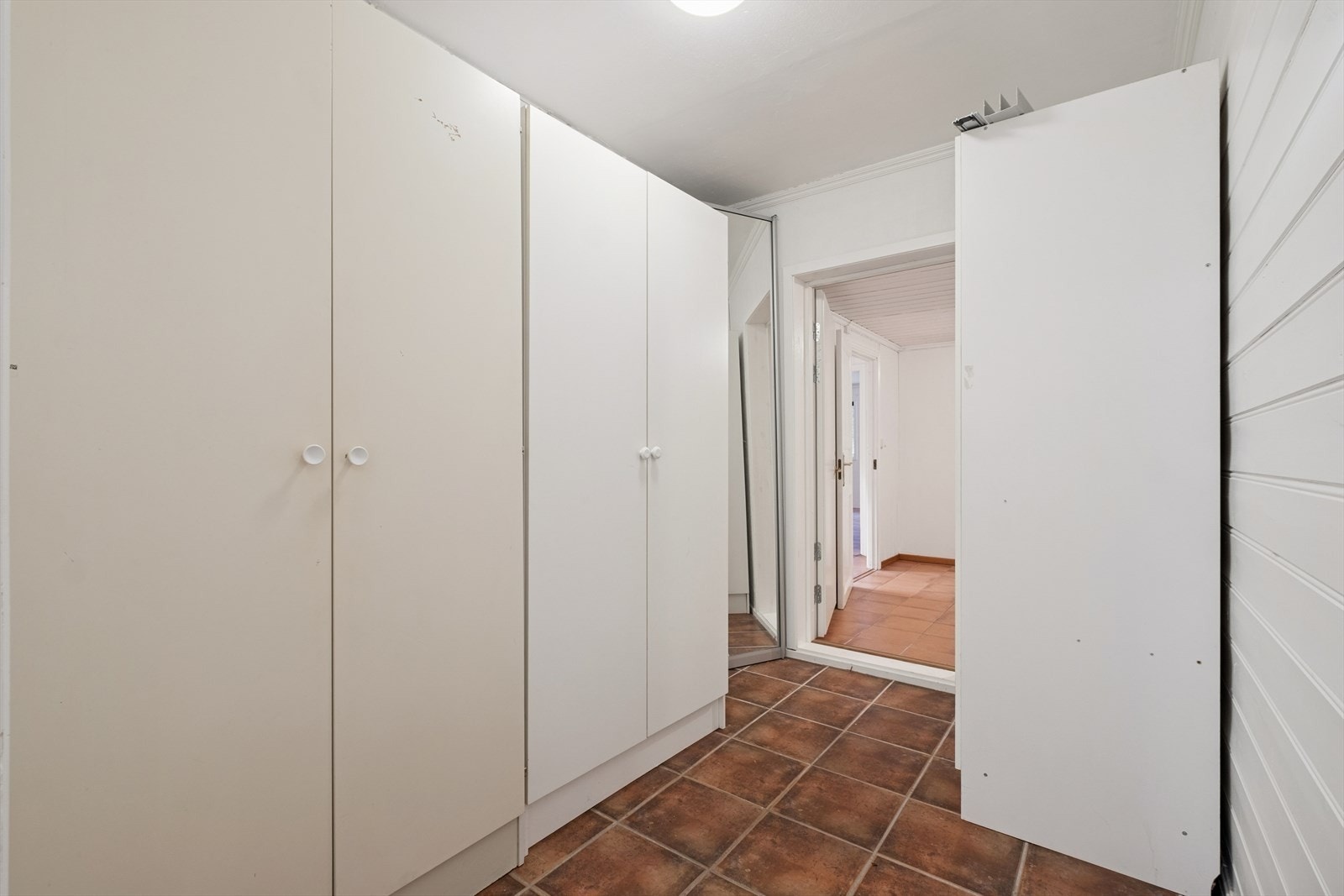 Mellom kjøkkenet og den andre leiligheten har denne leiligheten en romslig gang, med gode oppbevaringsmuligheter i en garderobeløsning. Galleribilde