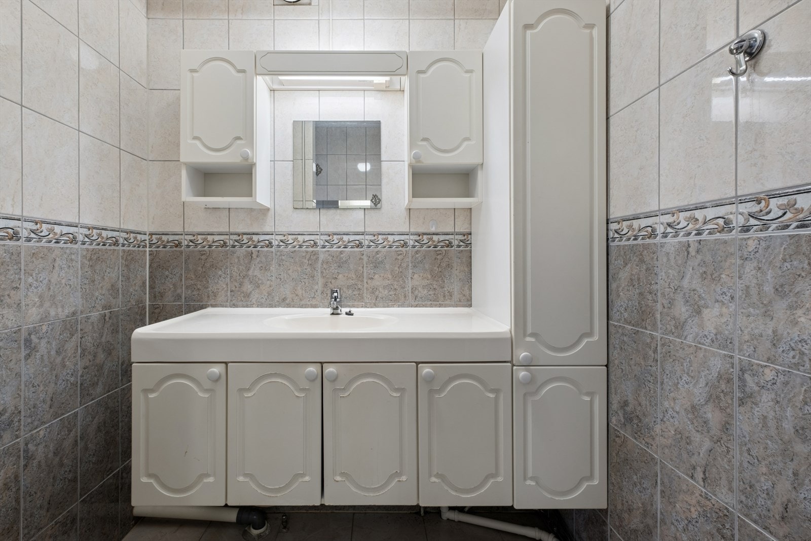 Romslig og flislagt baderom. Her er det innredning med underskap, og sideskap siden av servant. Det er antatt varmekabler på gulv. Galleribilde