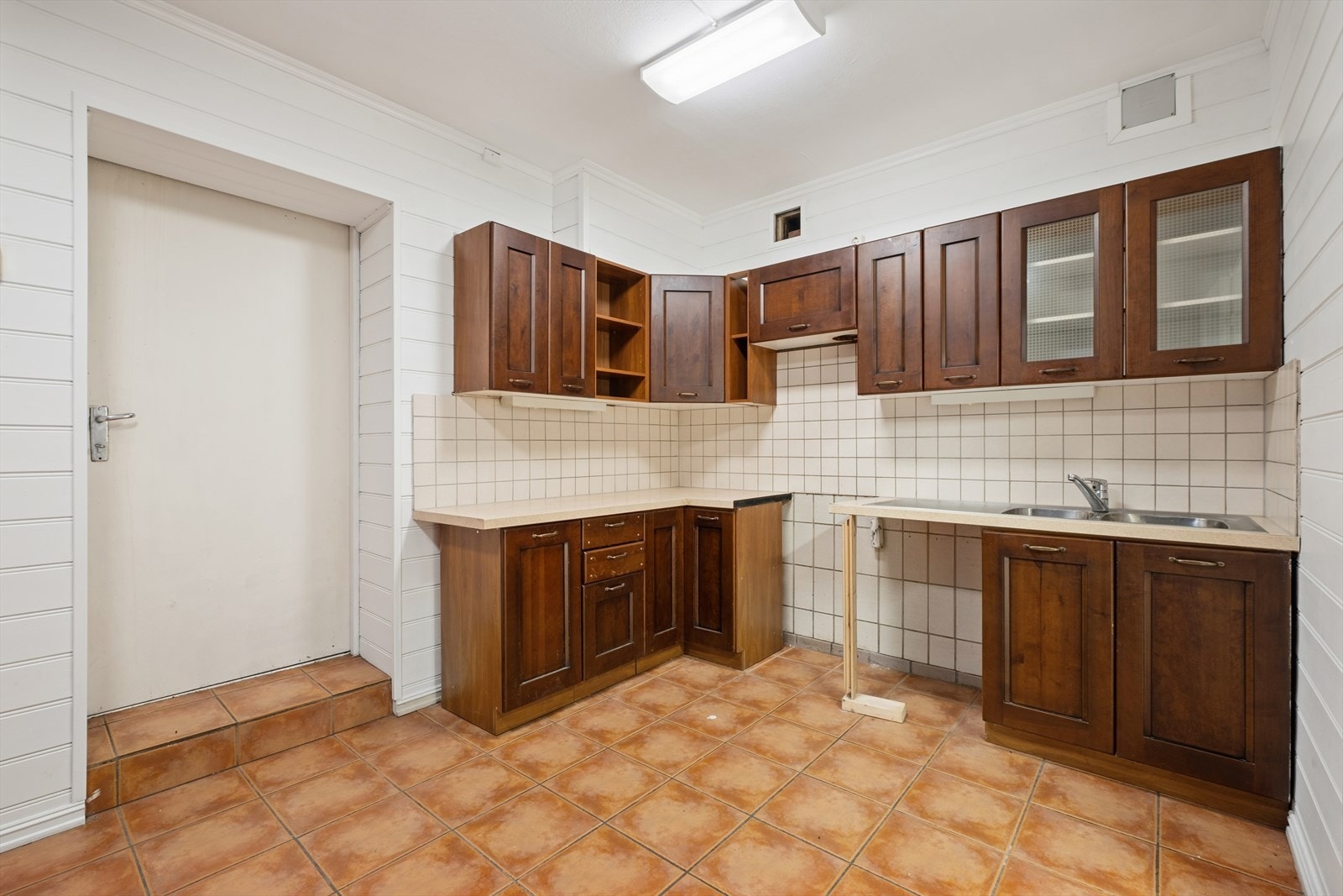 Den andre delen har en eldre kjøkkeninnredning med god skap- og benkeplass. Her er det utgang til den solrike plattingen. Galleribilde