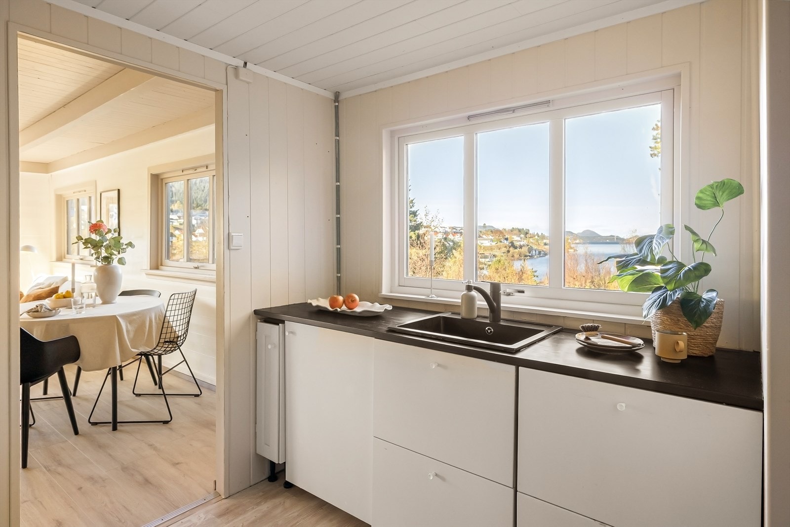 Innredningen består av slette og profilerte fronter, laminat/malt heltre benkeplate, sort kvarts kompositt vaskekum og ventilator. Galleribilde