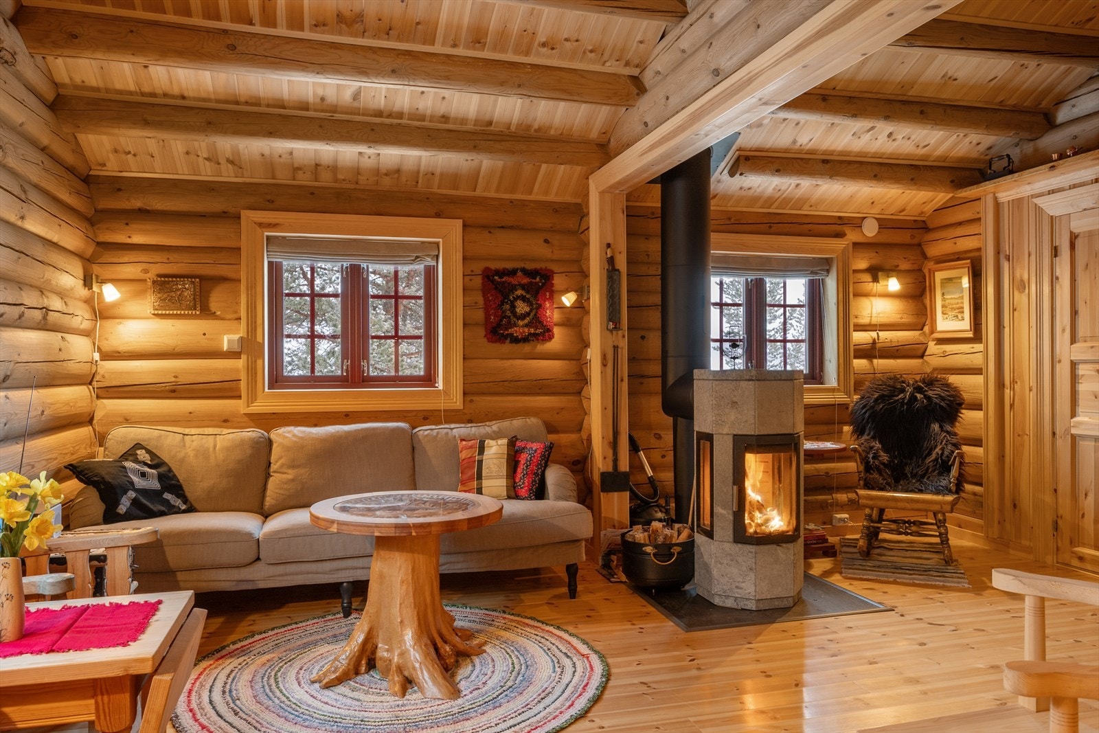 Stua fremstår lun og innbydende med en flott klebersteinovn som pryder rommet. Galleribilde