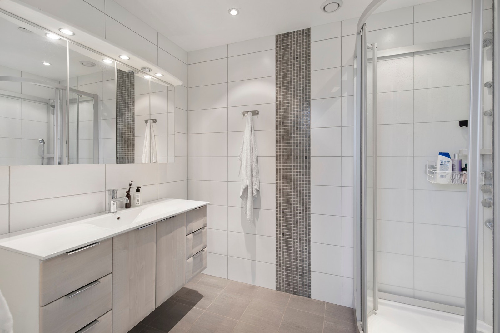 Badet på loftet er utstyrt med varme i gulv, dusjkabinett, vegghengt toalett og baderomsinnredning med speilskap og belysning. Galleribilde