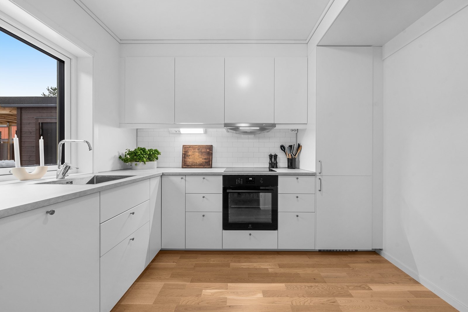 Kjøkkeninnredningen har laminat benkeplate, integrerte hvitevarer og ventilator. Galleribilde