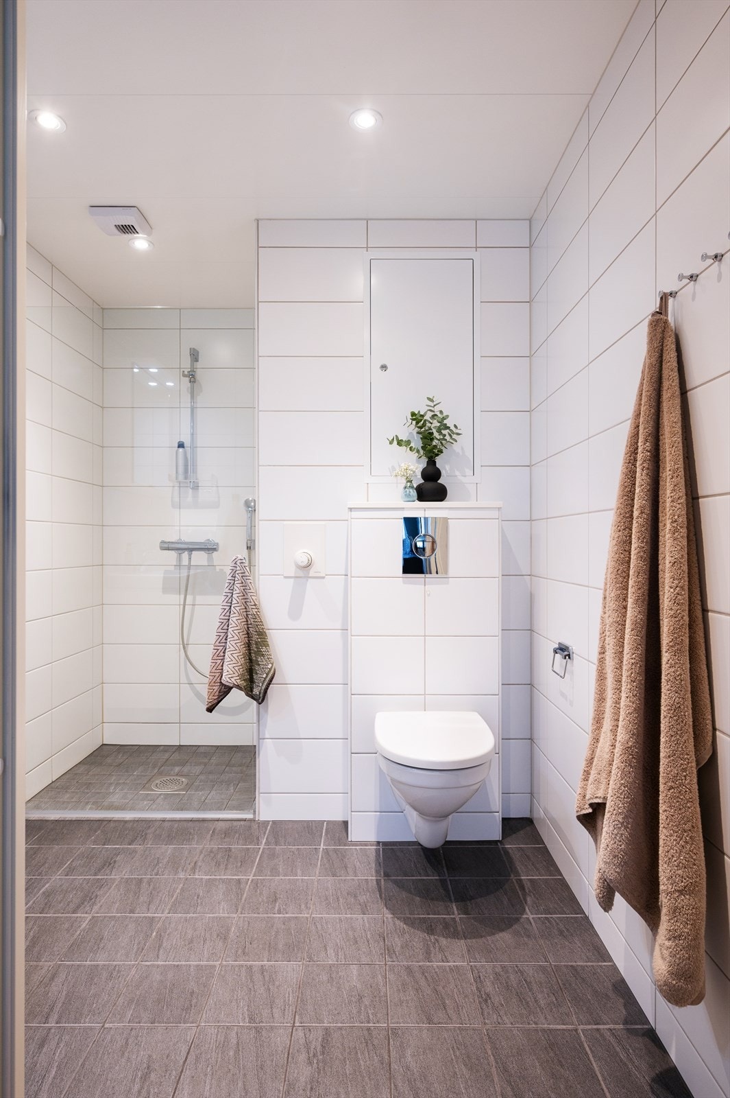 Her har man vannbåren gulvvarme, vegghengt toalett, servant nedfelt i innredning, speil og dusjhjørne med svingbar glassdør. Galleribilde