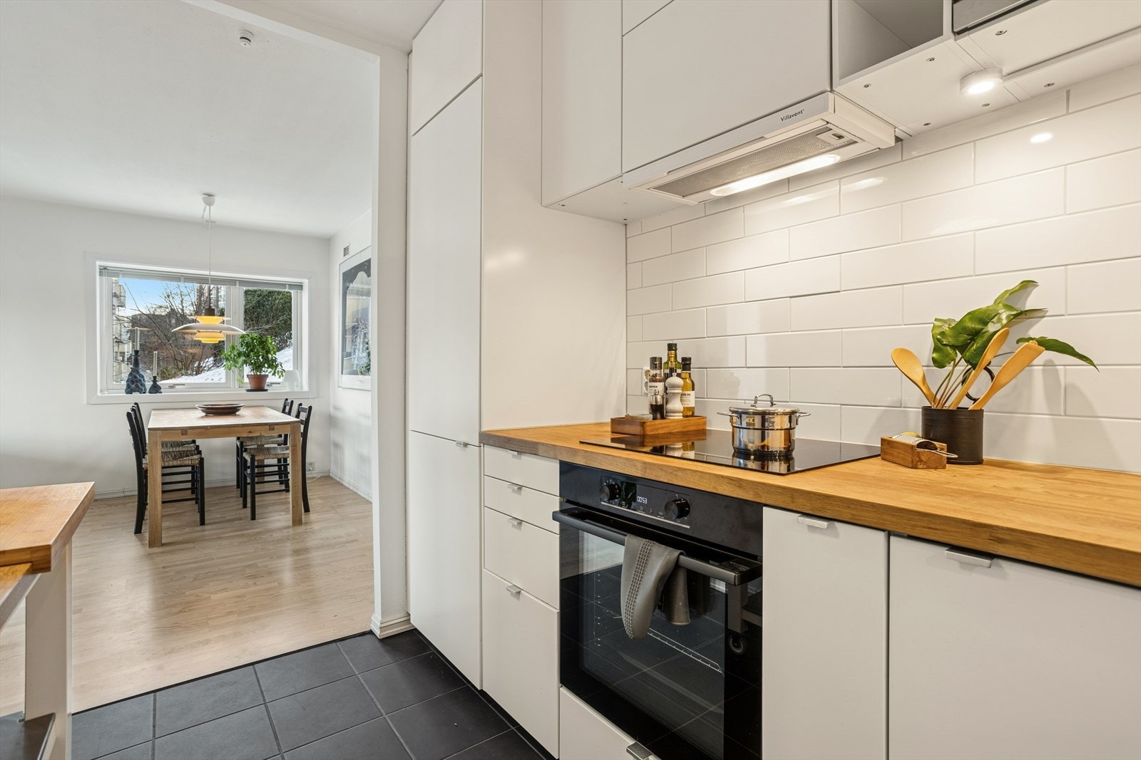 Kjøkkenet har en innredning med glatte fronter, over- og underskap, og en benkeplate i heltre. Galleribilde