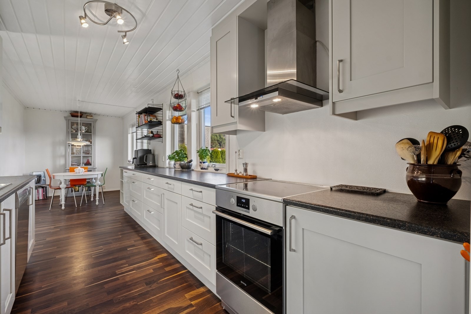 Kjøkkenet fra 2011 har hvite profilerte fronter og laminat benkeplate Galleribilde