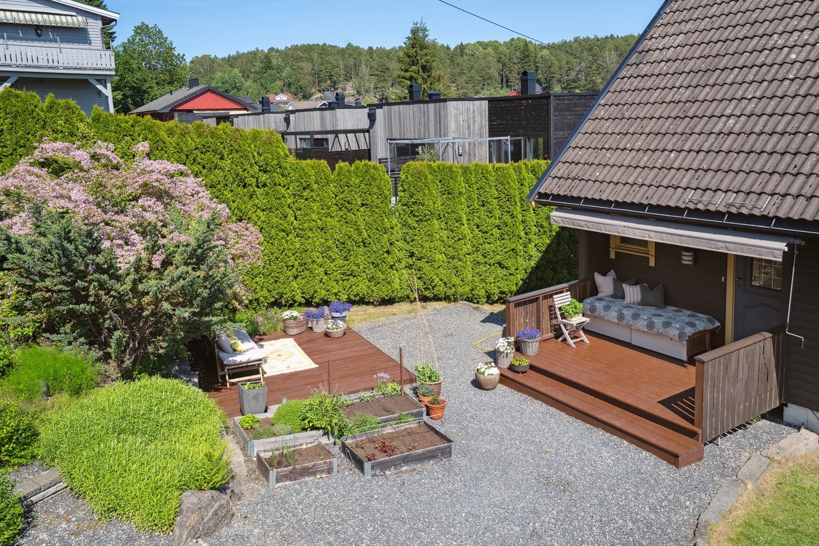 Tomten er pent opparbeidet med diverse prydbusker. Skjermet med hekk mot naboer Galleribilde