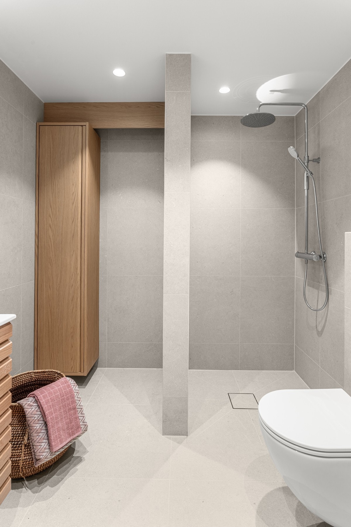 Hovedbadet har i tillegg egen vaskesone med høyskap i nisje for vaskemaskin og tørketrommel i søyleløsning. Skyvedør i glass monteres slik at denne dekker dusjnisje ved dusjing og dekker vaskenisje når man ikke dusjer Galleribilde