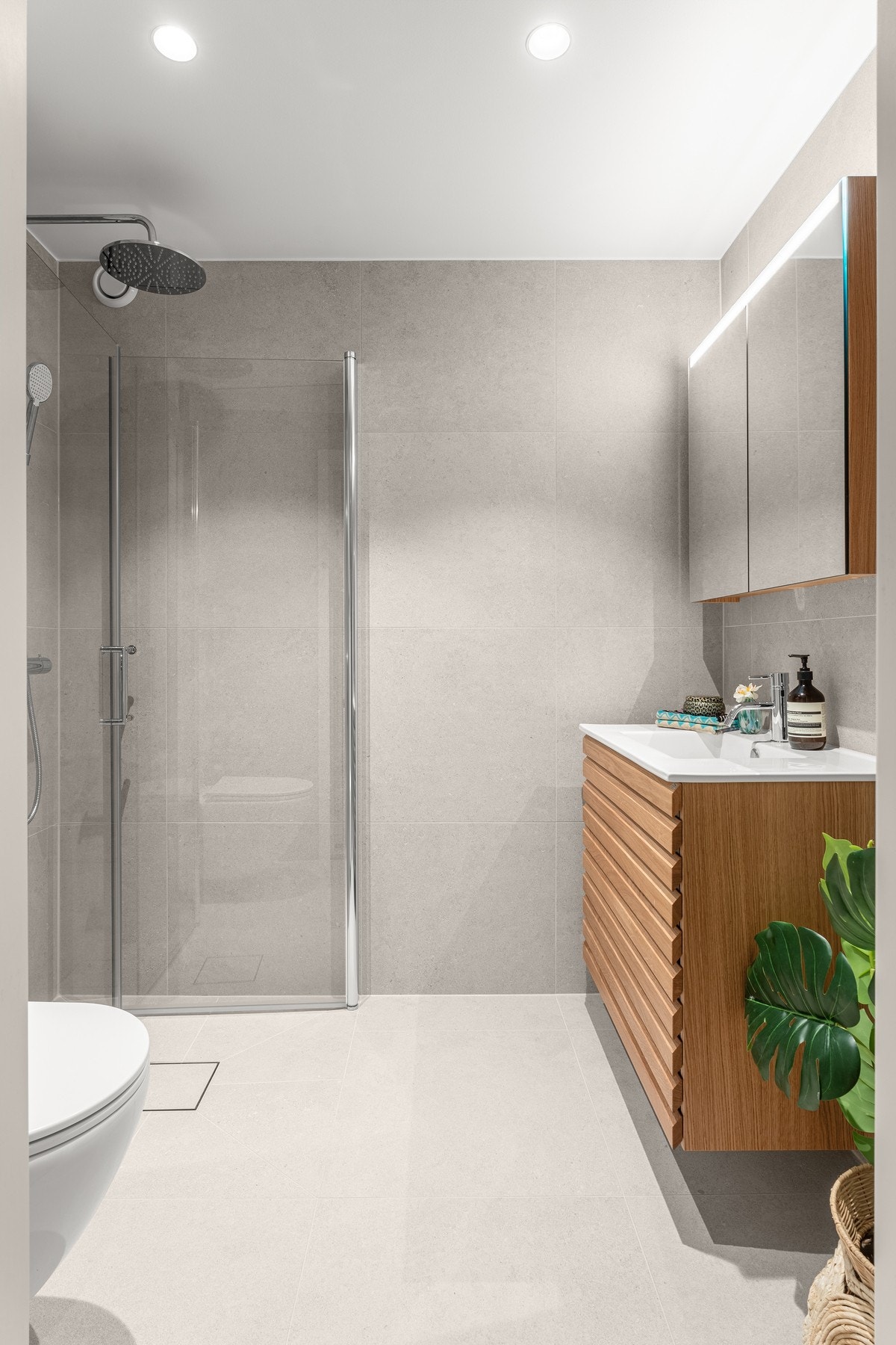 Begge har flislagte overflater, vegghengt toalett, regnfallsdusj og naturtro innredning med spilefronter Galleribilde