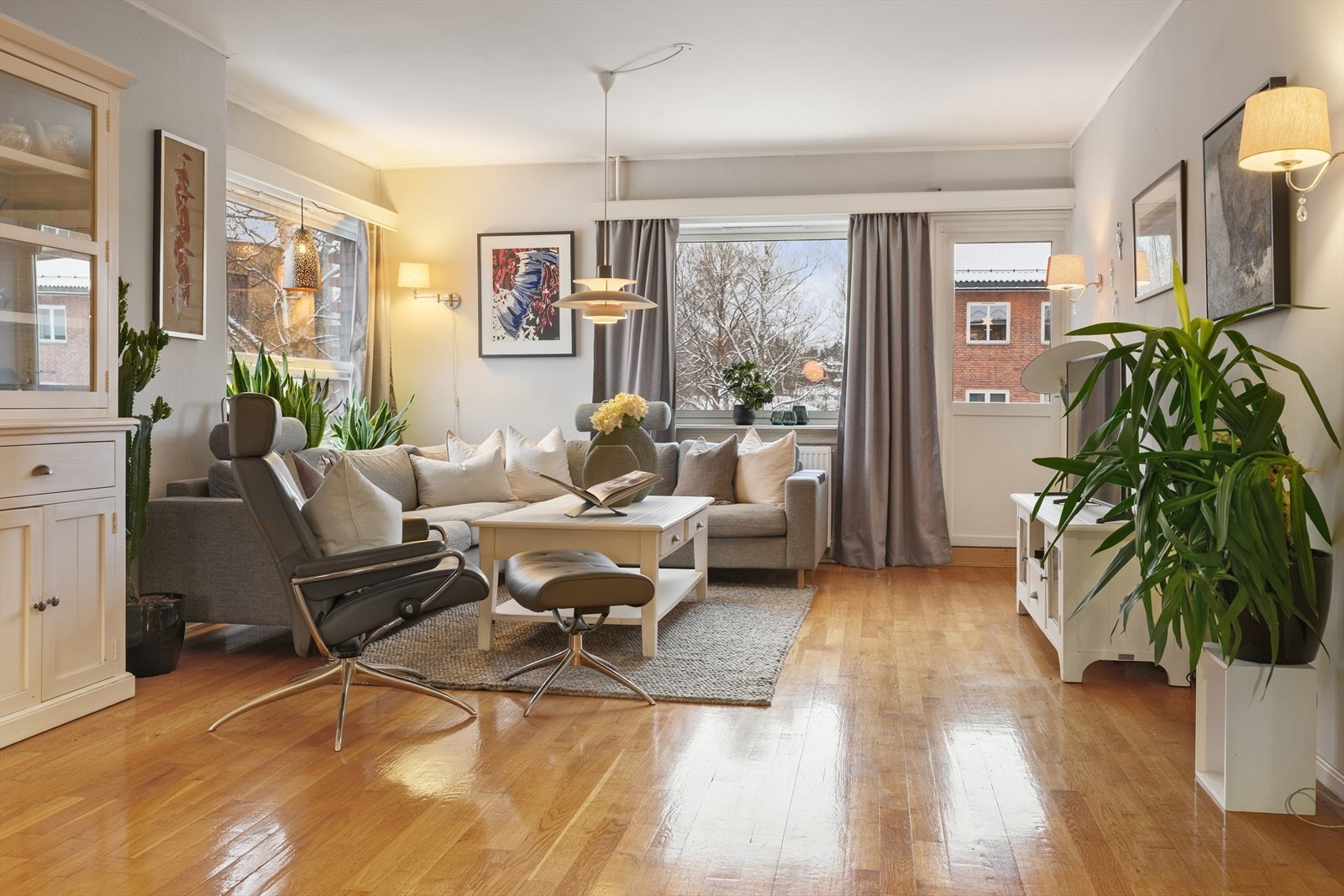 Leiligheten ligger på hjørnet av bygget og de store og mange vinduene slipper inn rikelig med dagslys Galleribilde