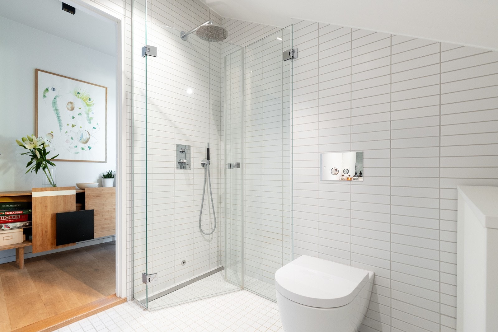 Det er dusjhjørne med innfellbare dører i glass, vegghengt toalett og opplegg for vaskemaskin. Galleribilde