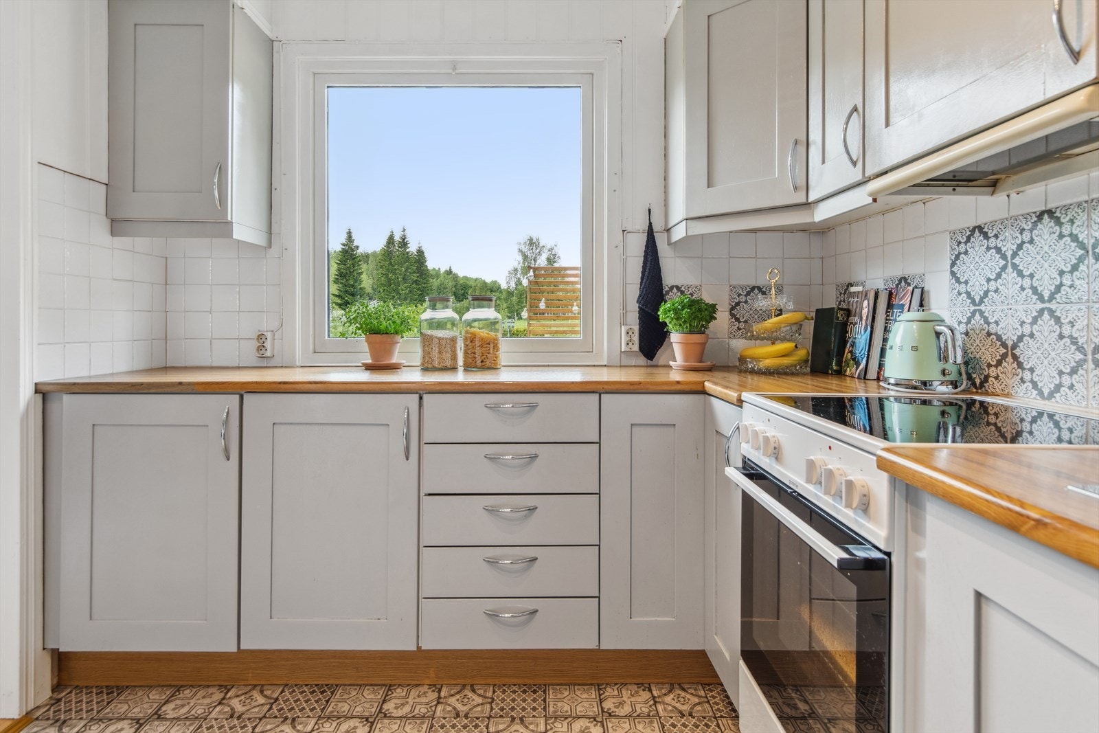 Kjøkkenet har godt med benkeplass. Over benken er det foliebelagte fliser, og en lyslist under overskapene gir godt arbeidslys. Galleribilde