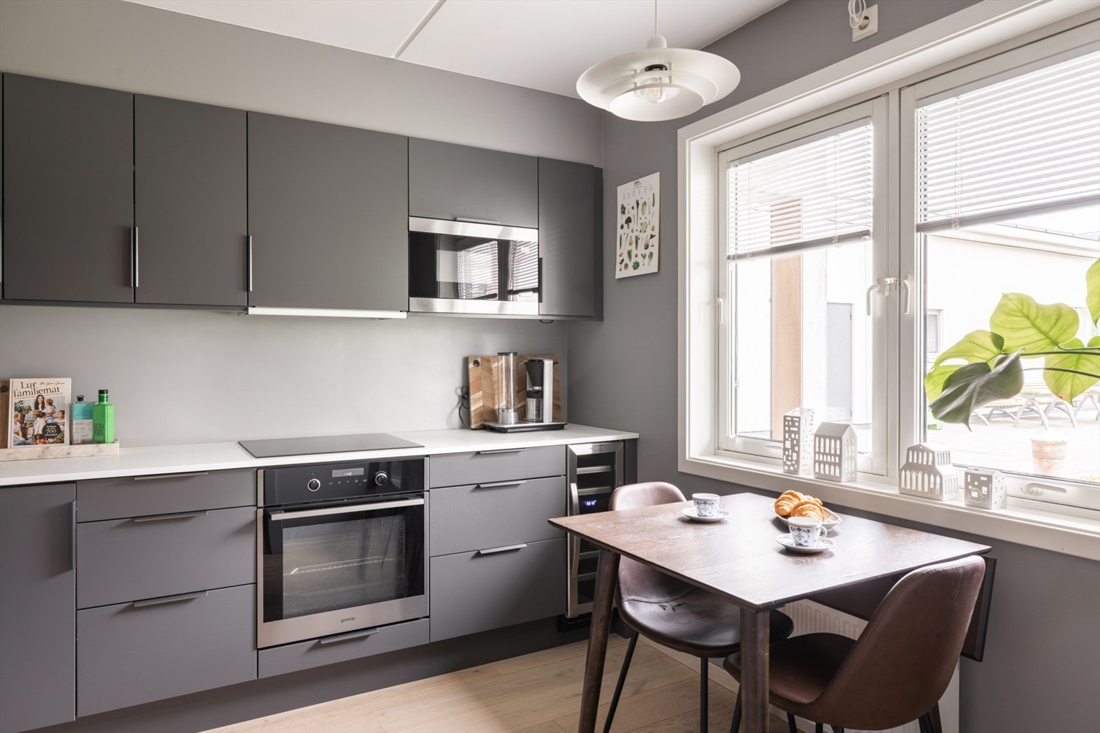 Et stort vindu vendt mot indre gårdsrom gir godt med dagslys og en hyggelig utsikt, rommet har også plass til spisebord for sosiale måltider. Galleribilde