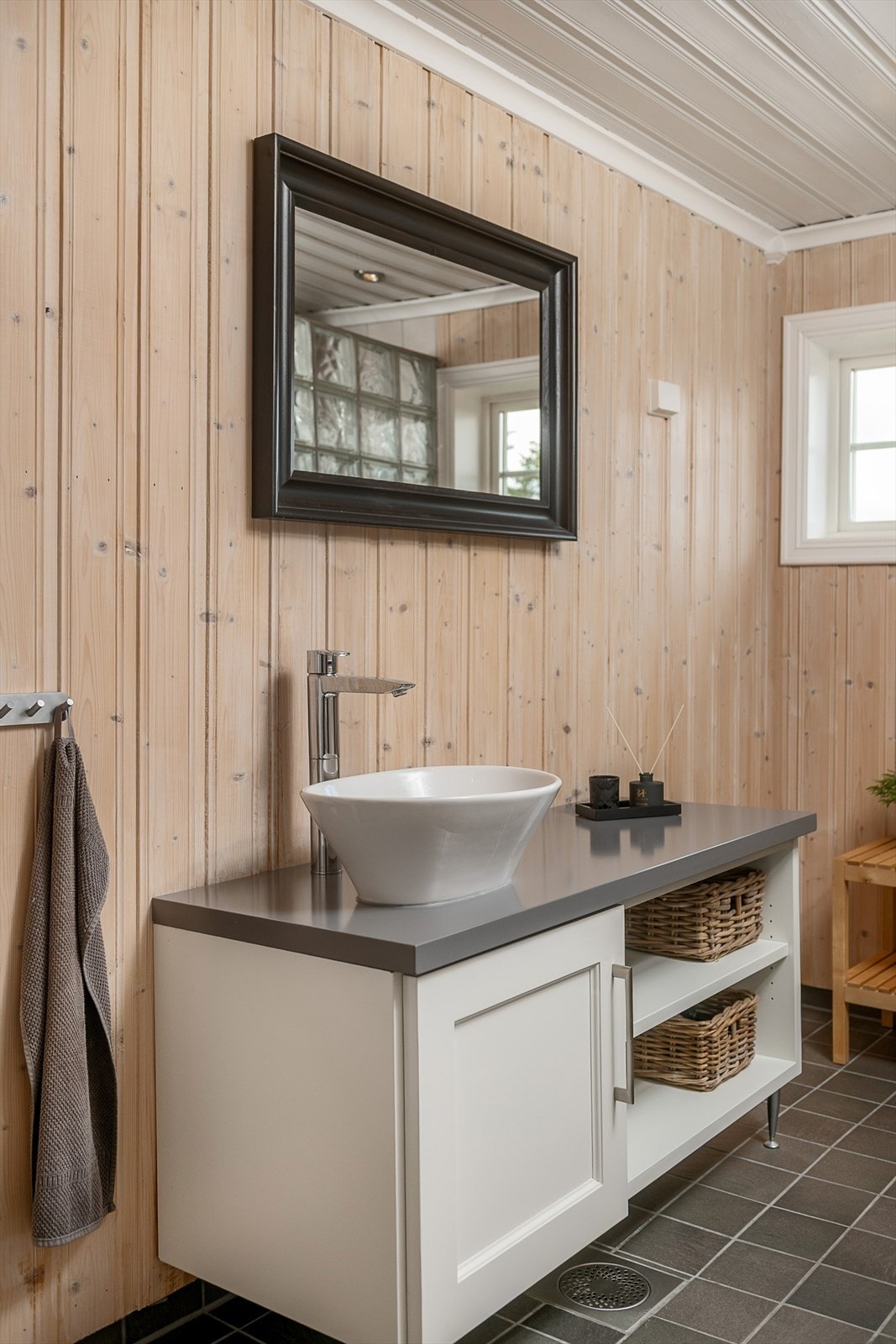 Baderomsinnredningen har skap og hyller for oppbevaring. Galleribilde