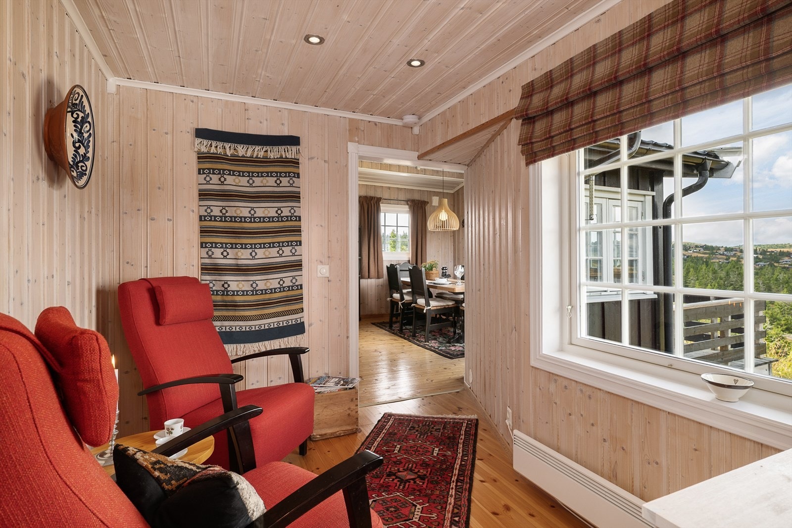 En hyggelig liten stue innenfor kjøkkenet er møblert med stoler. Et fint sted å nyte utsikten fra, i alt slags vær. Galleribilde