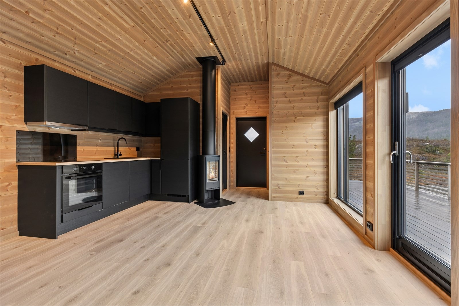 Hytten er meget arealeffektiv, med lys og åpen stue/kjøkkenløsning, 2 soverom, baderom og 2 boder. Galleribilde